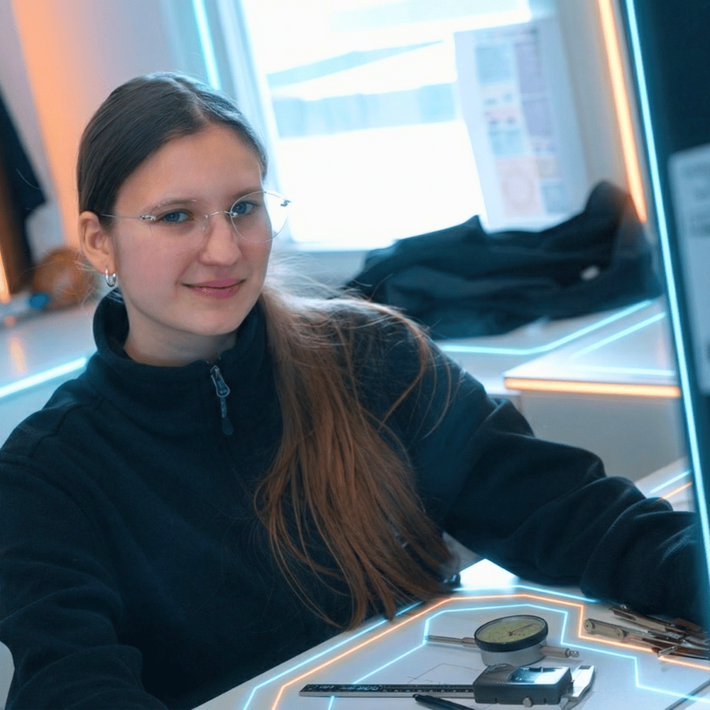 LINCK-Auszubildende sitzt am PC, tippt auf der Tastatur und lächelt in die Kamera