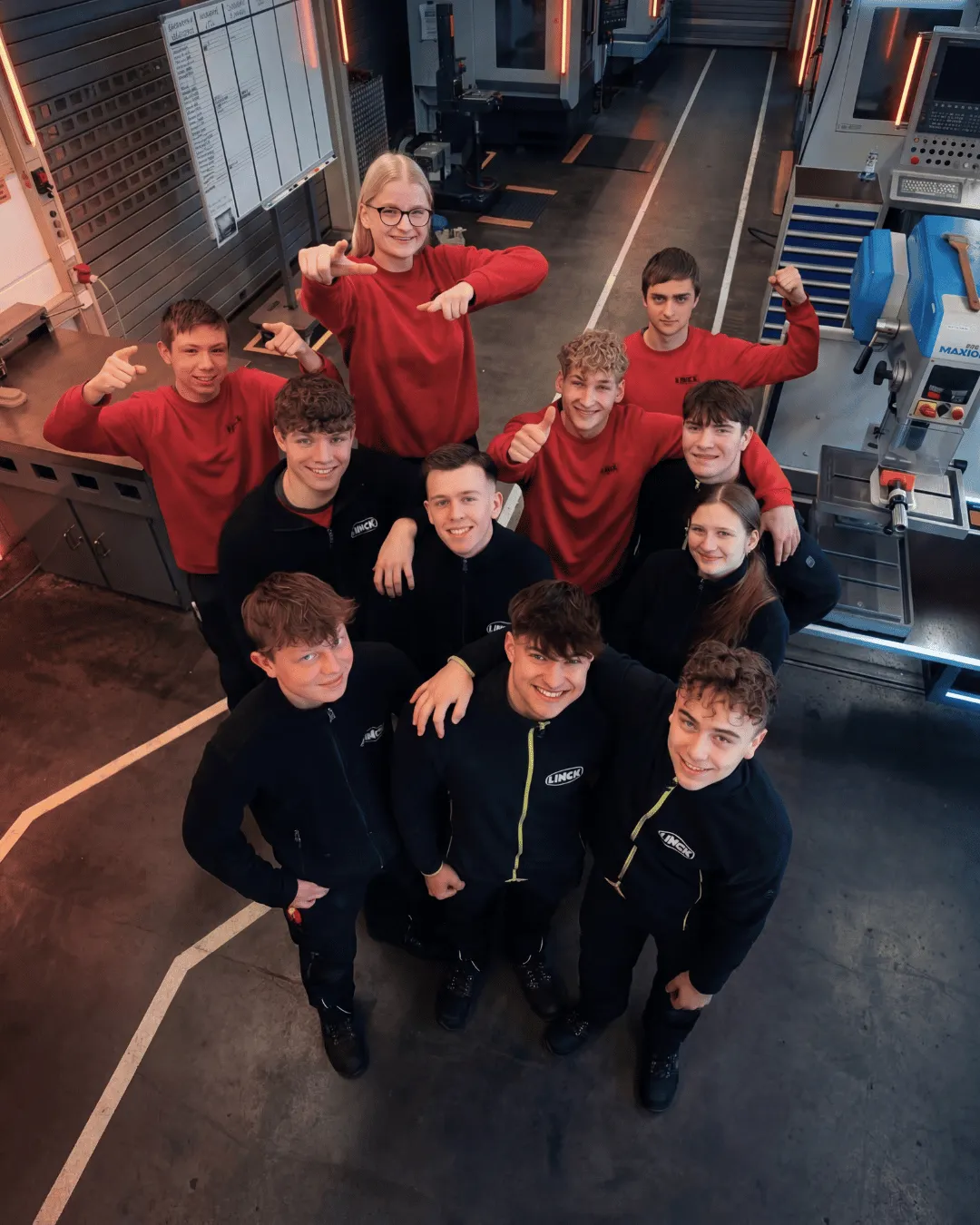 Gruppenaufnahme von oben mit LINCK-Auszubildenden, die nach oben in die Kamera blicken und verschiedene Posen einnehmen