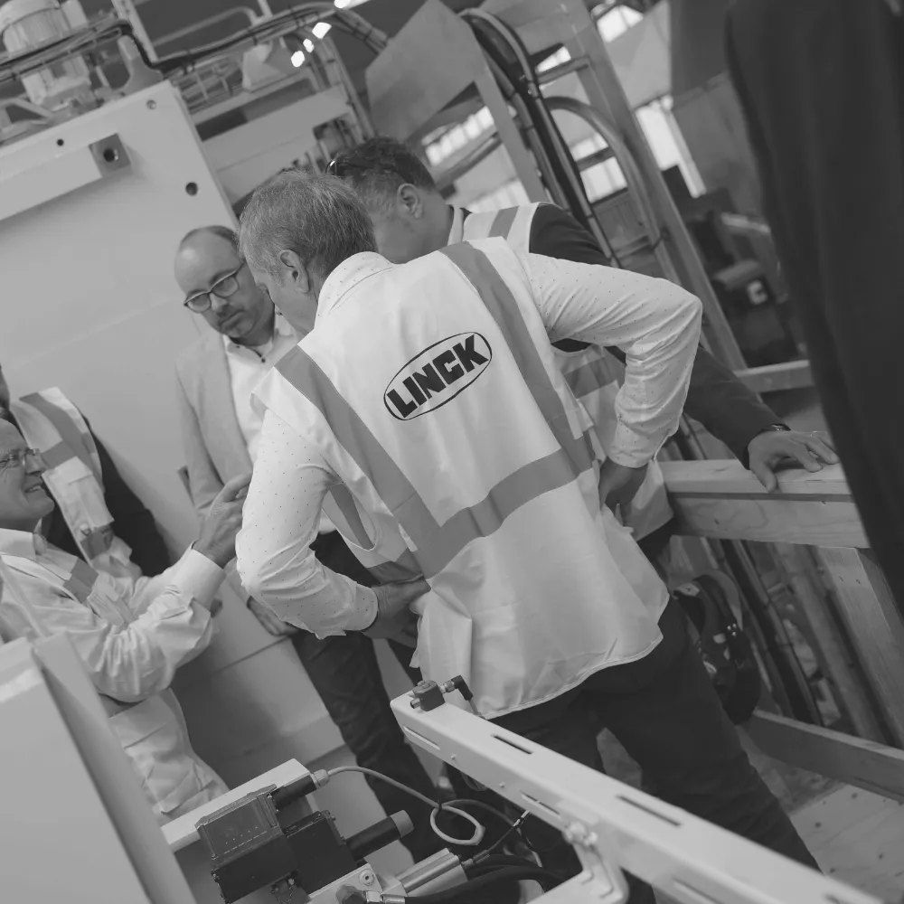 Besuch von Schweighofer. Fünf Personen stehen im Kreis und unterhalten sich. Dabei ist das LINCK Logo der Sicherheitswesten der Fokus.