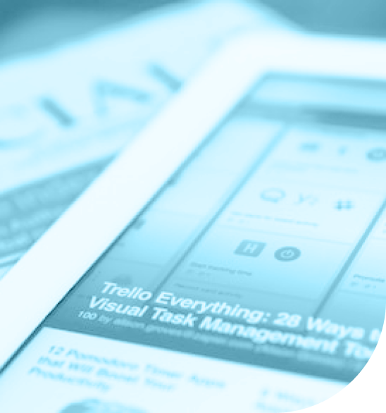 Close-up of a tablet screen displaying an article about Trello and task management apps, with blurred background text.