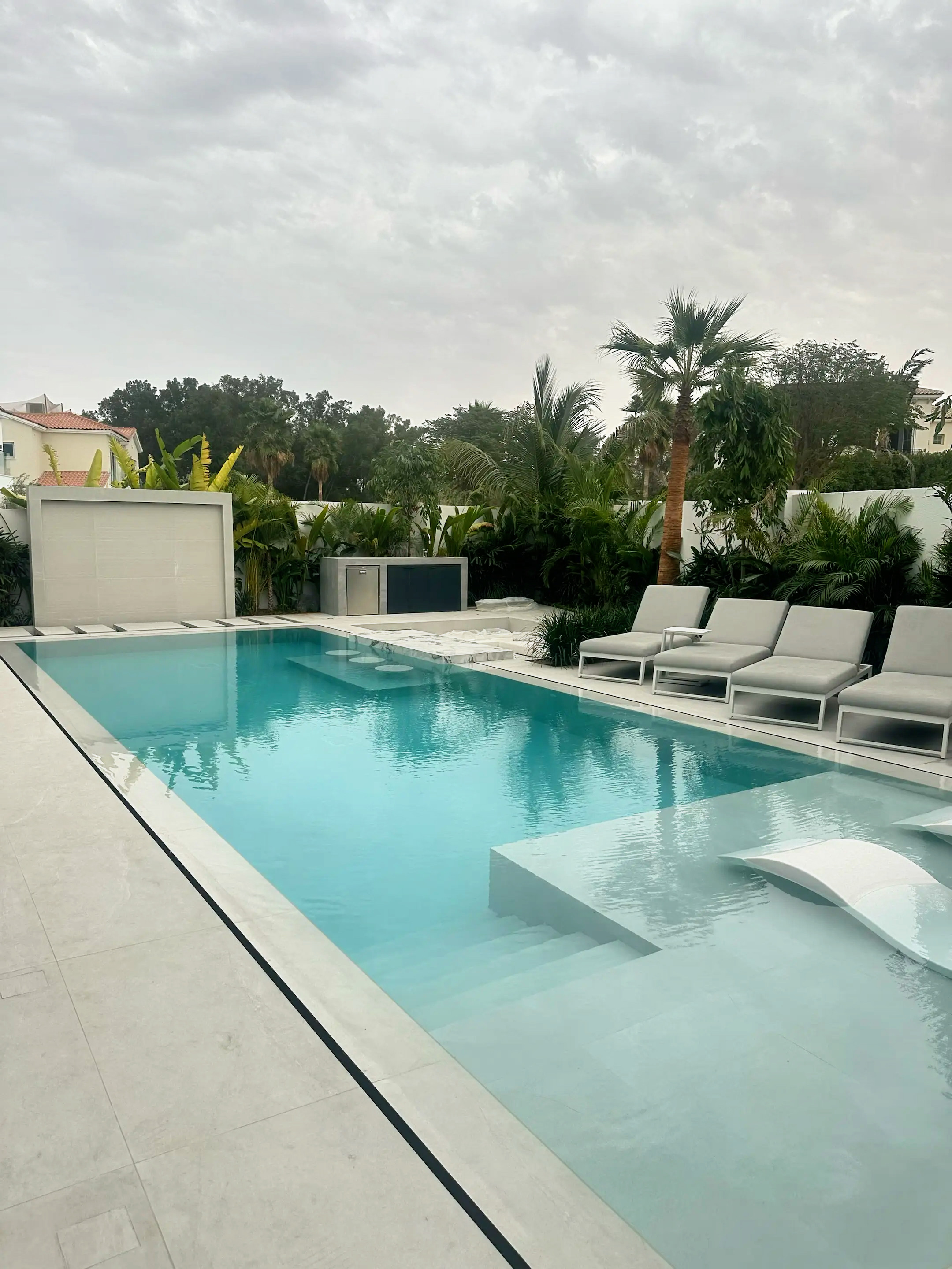 Construction site with concrete block structures and wooden framework for support next to a wall.