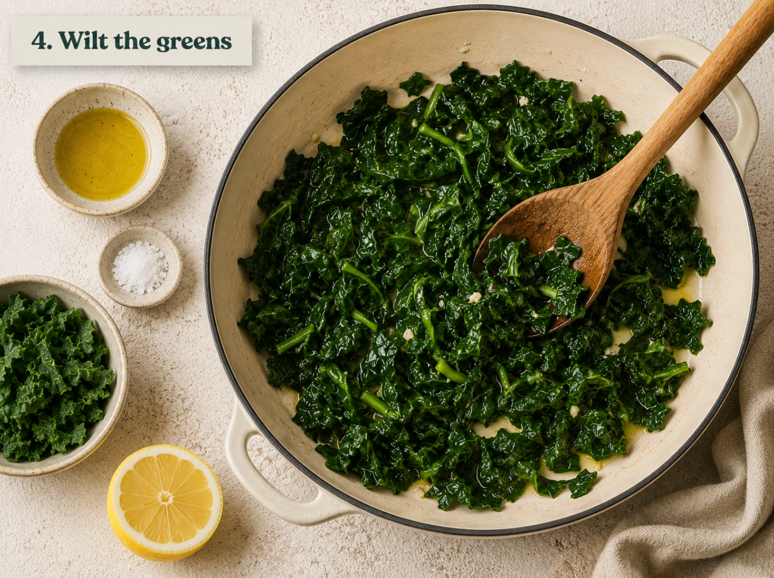 Kale collapsed to dark glossy green in a shallow pan with a squeeze of lemon.