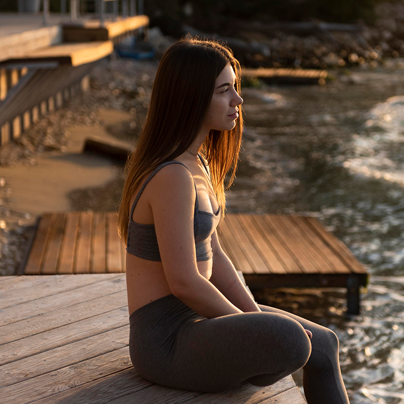 Une femme au bord de la mer, scrutant l'horizon, coucher de soleil