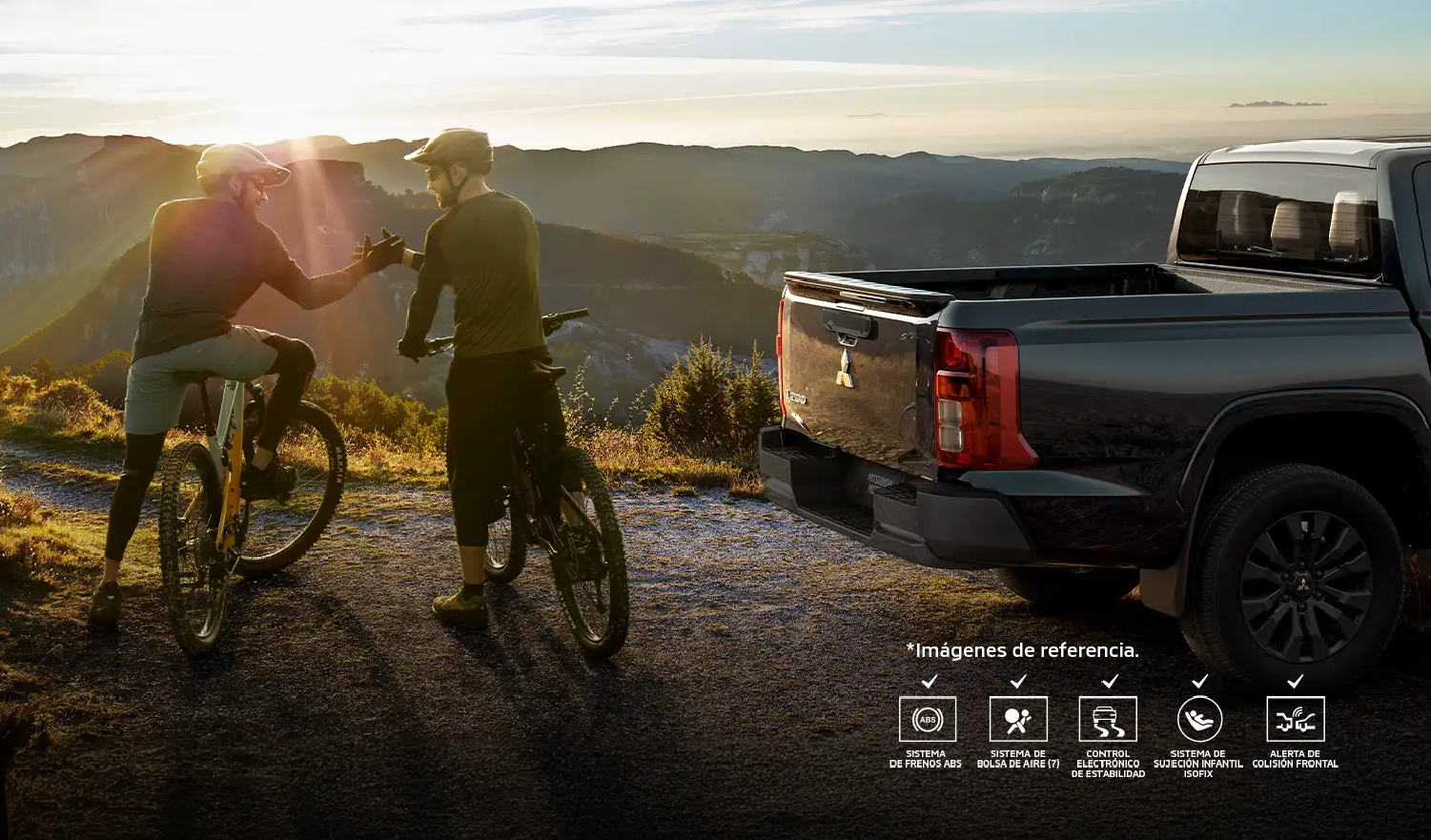 Mitsubishi L200 con dos ciclistas en la montaña