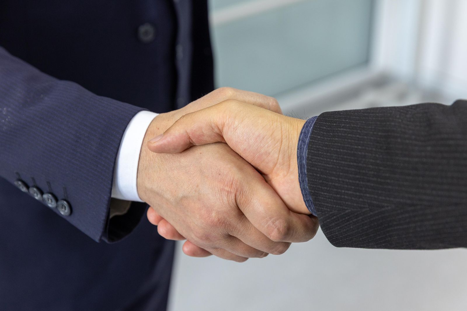 Two business professionals shaking hands after a sales meeting