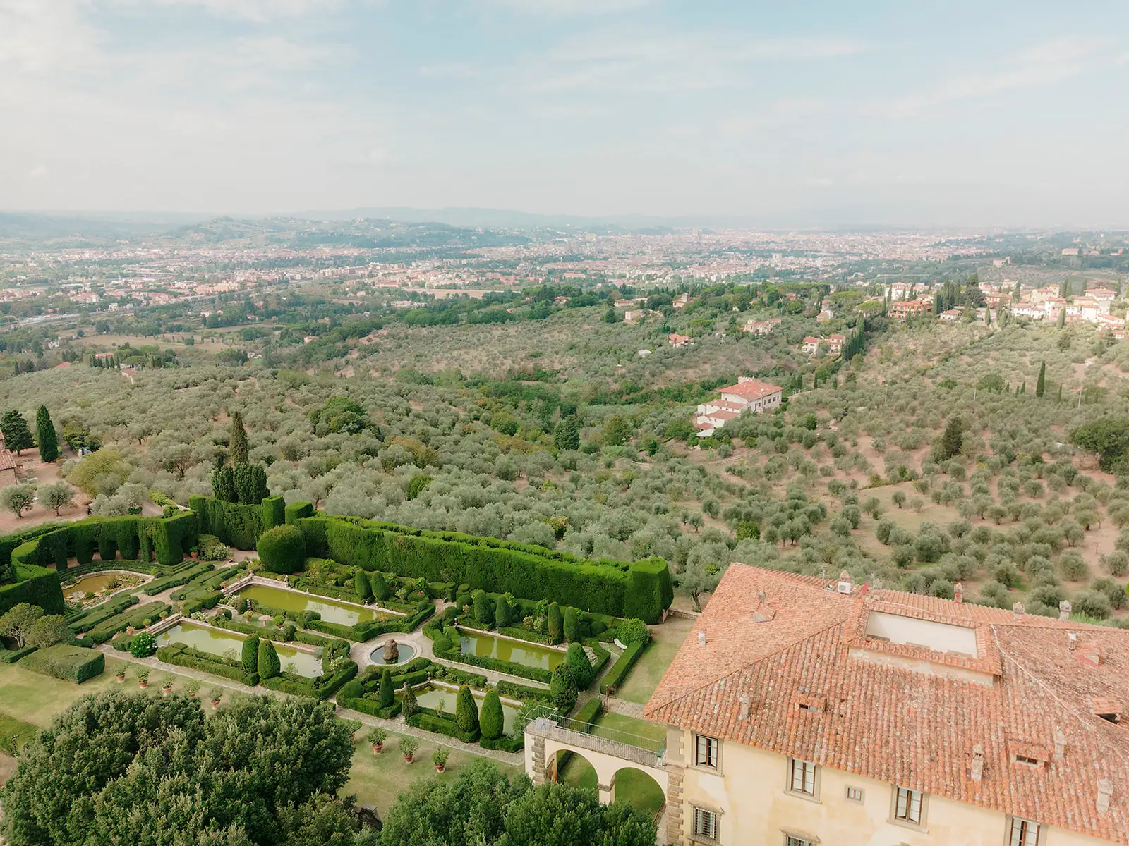 Aerial view of Italian countryside with manicured garden and terracotta roofs in Tuscany