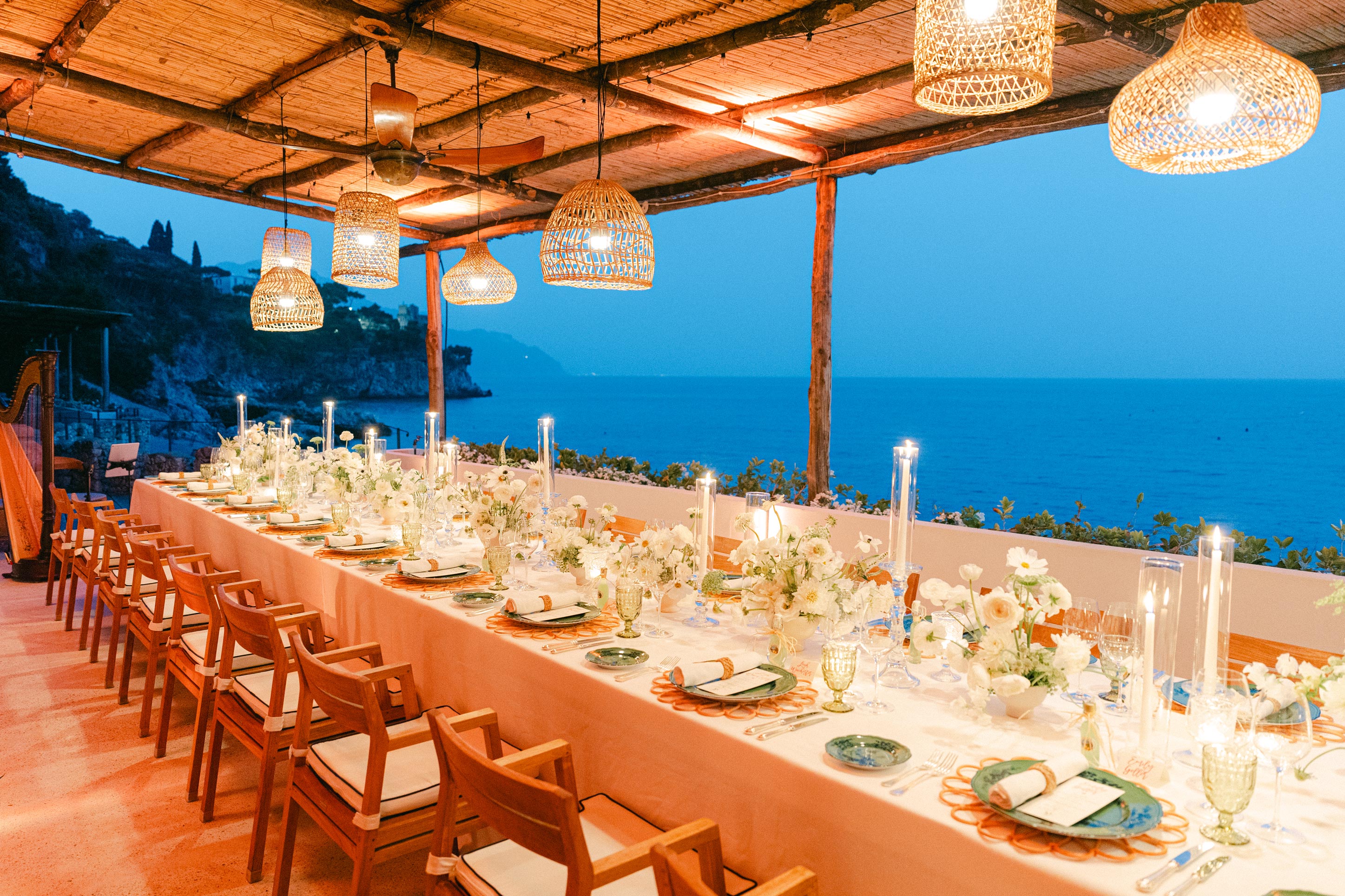 Elegant seaside dining table with woven lamps and stunning ocean view
