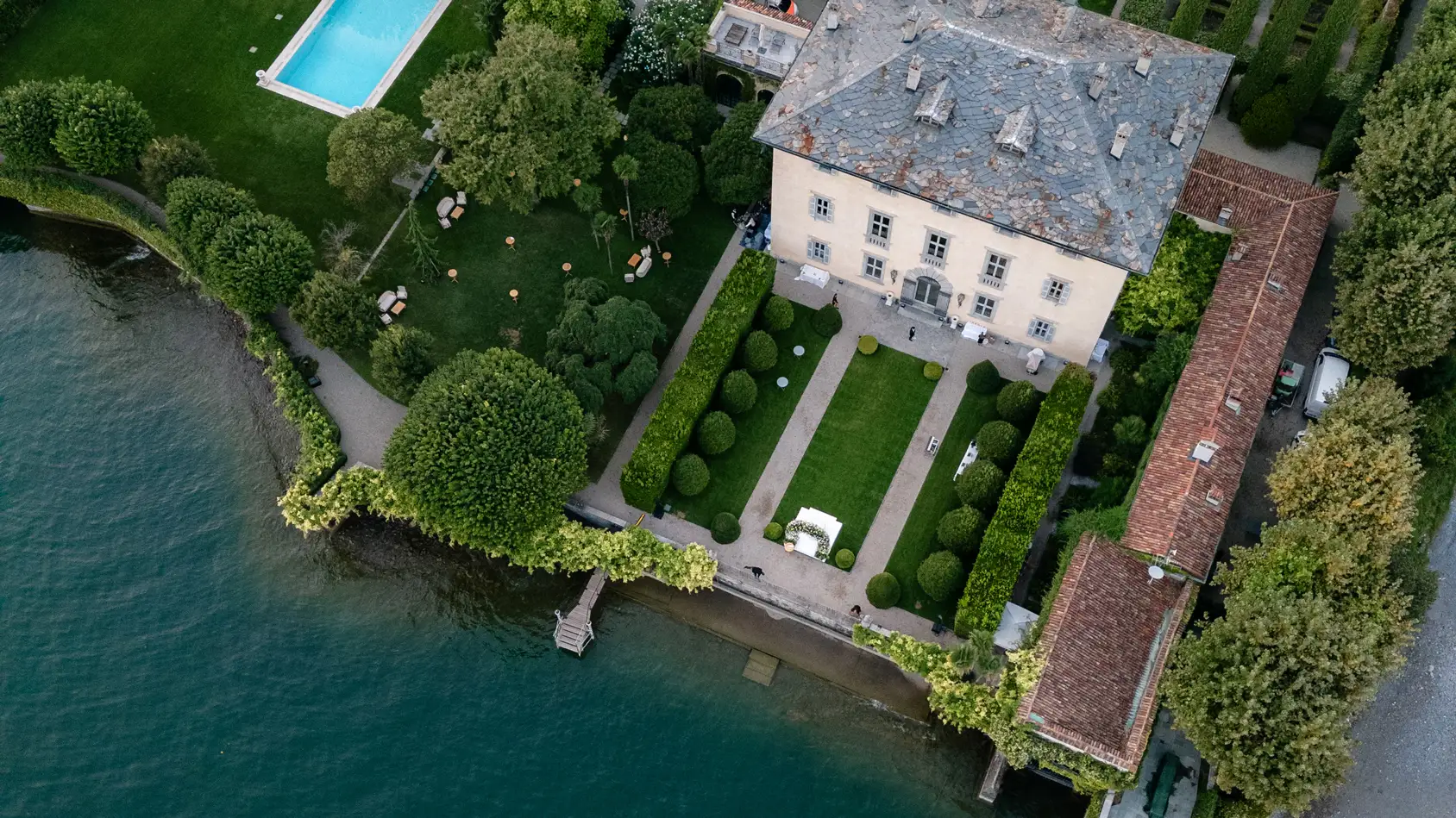Aerial view of elegant lakeside villa with manicured gardens and swimming pool on Lake Como