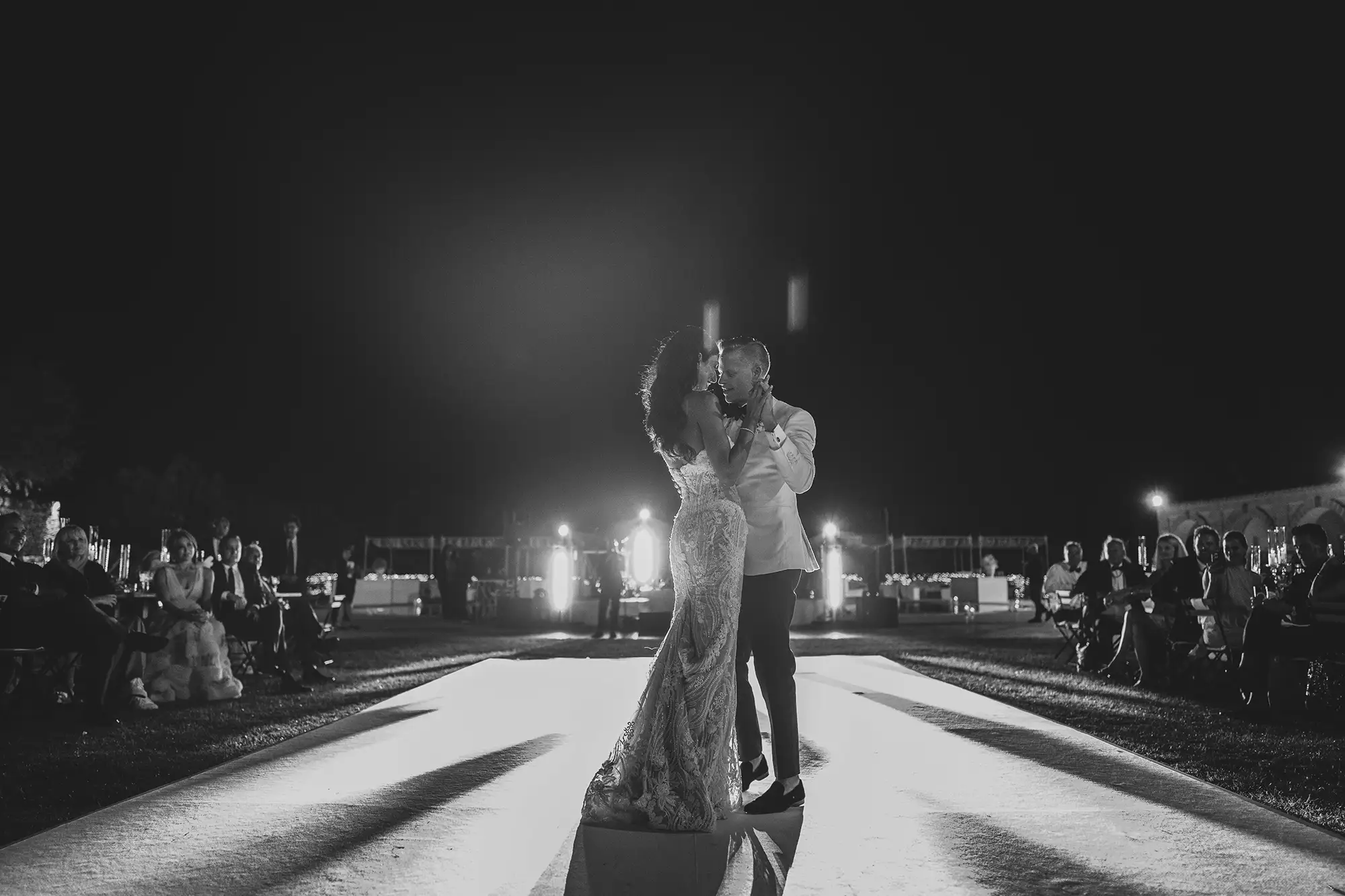 Romantic black and white wedding dance with couple on illuminated path in Apulia, Italy