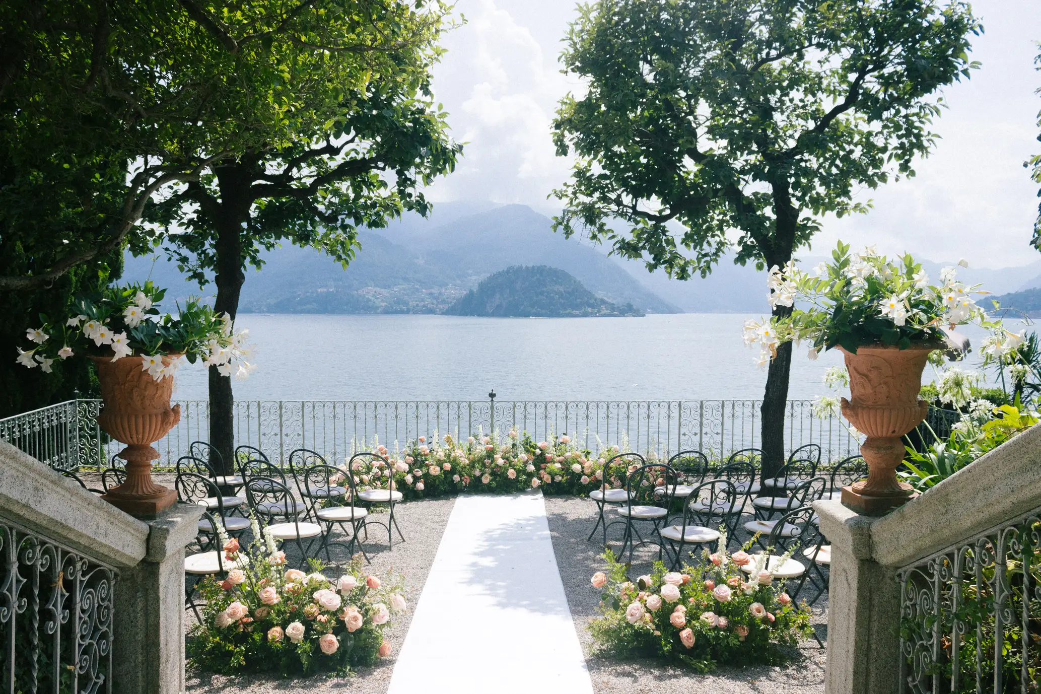 Romantic wedding ceremony setup overlooking Lake Como with mountain backdrop