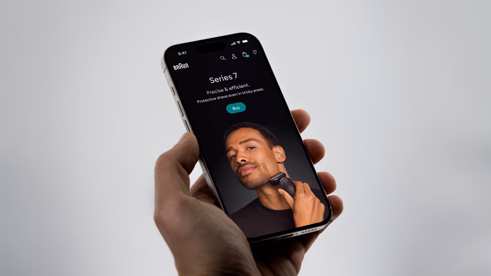Hand holding a smartphone displaying Braun's new website.