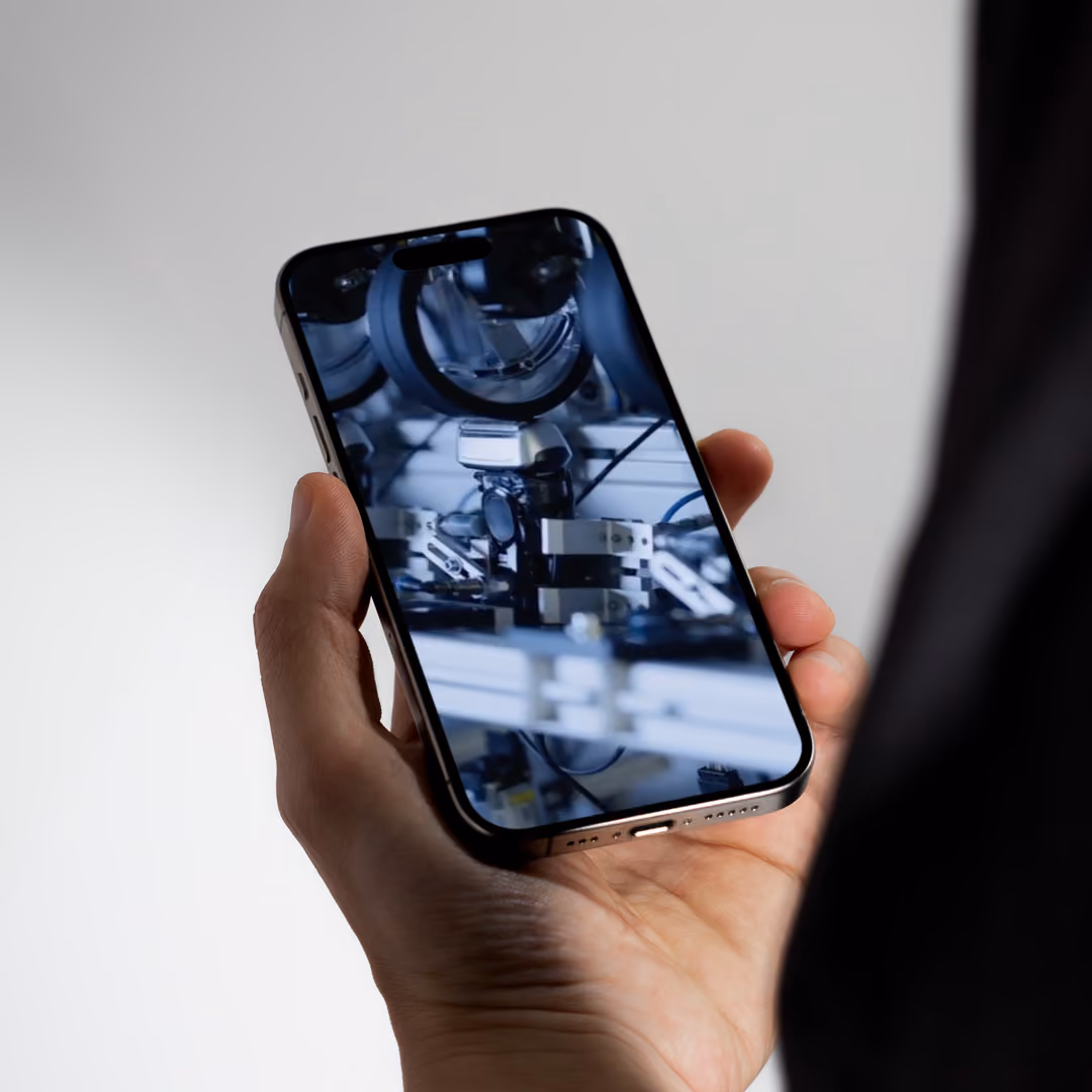 Hand holding smartphone displaying a close-up of a electric shaver durability test.