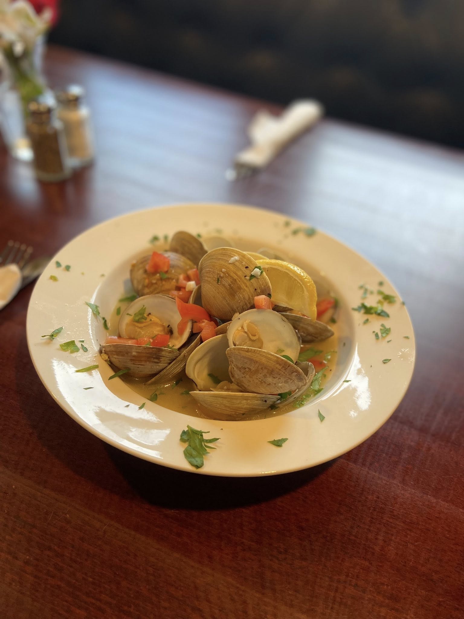 A white plate with a bowl of food on a table.