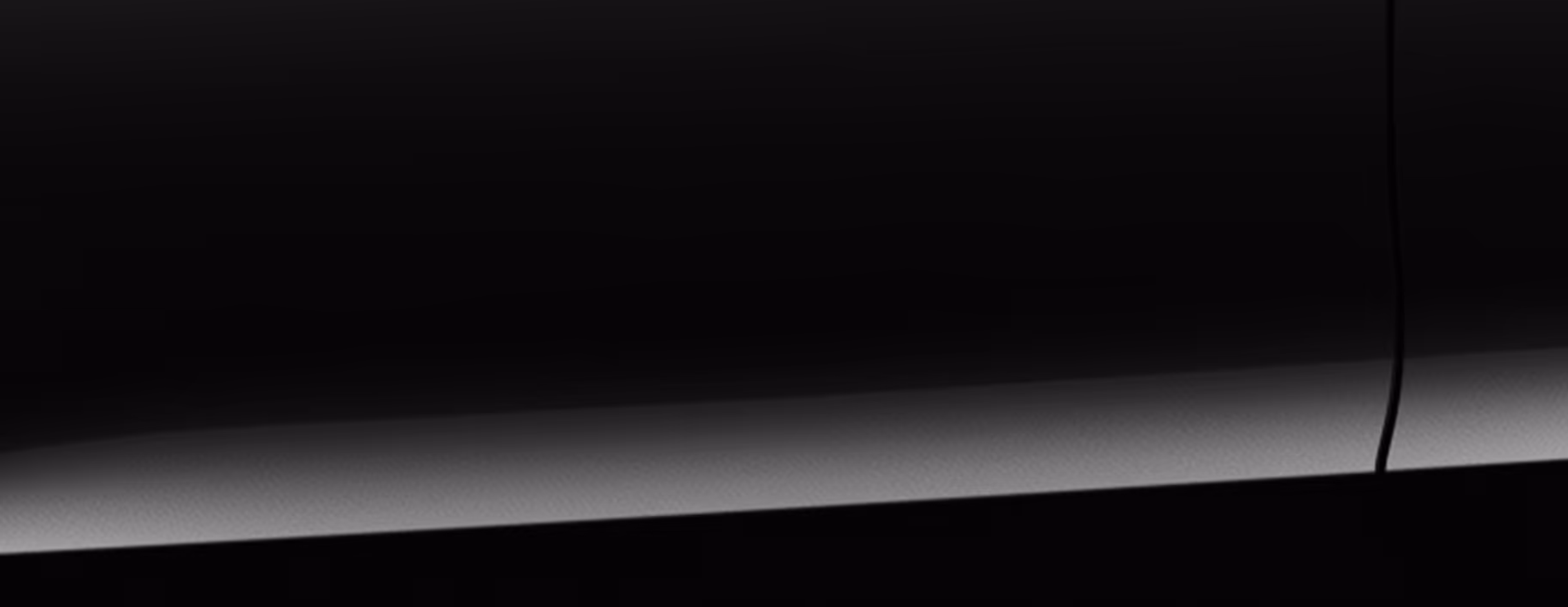 Eine minimalistische Detailaufnahme zeigt einen Ausschnitt der Karosserie des Škoda Octavia Balance in der Lackierung Black-Magic Perleffekt. 
