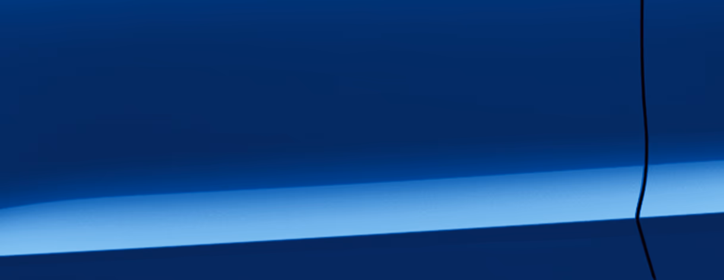 Eine minimalistische Detailaufnahme zeigt einen Ausschnitt der Karosserie des Škoda Octavia Balance in der Lackierung Race-Blau Metallic. 
