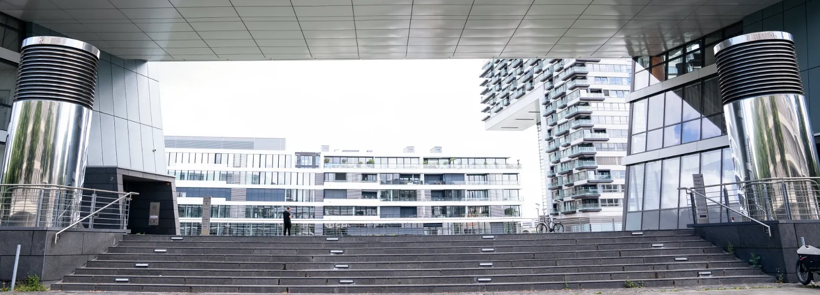 Moderner Gebäudedurchgang des Microsoft Gebäudes in Köln mit breiten Treppen.