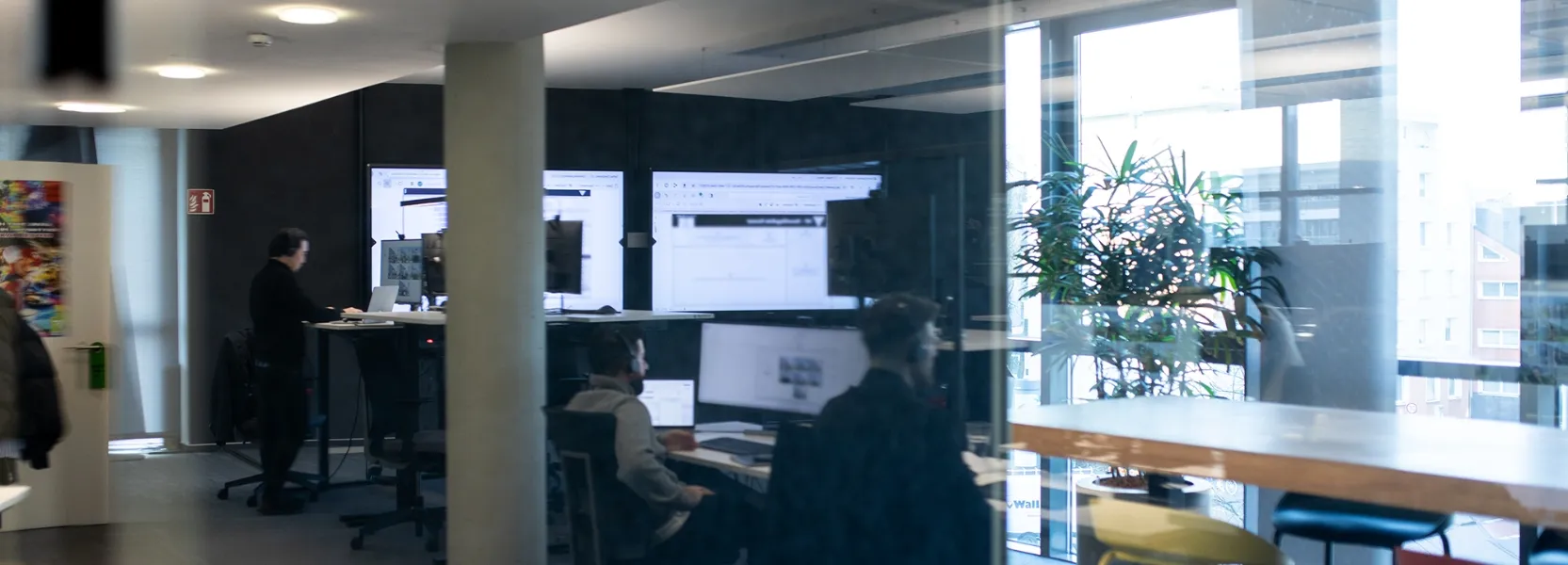 Ein Mann gibt einen Vortrag vor einem Bildschirm mit der Überschrift 'Was sind virtuelle Agenten?' und vier Informationsfeldern zu Sprachverarbeitung, automatisierten Aufgaben, maschinellem Lernen und Plattformintegration.