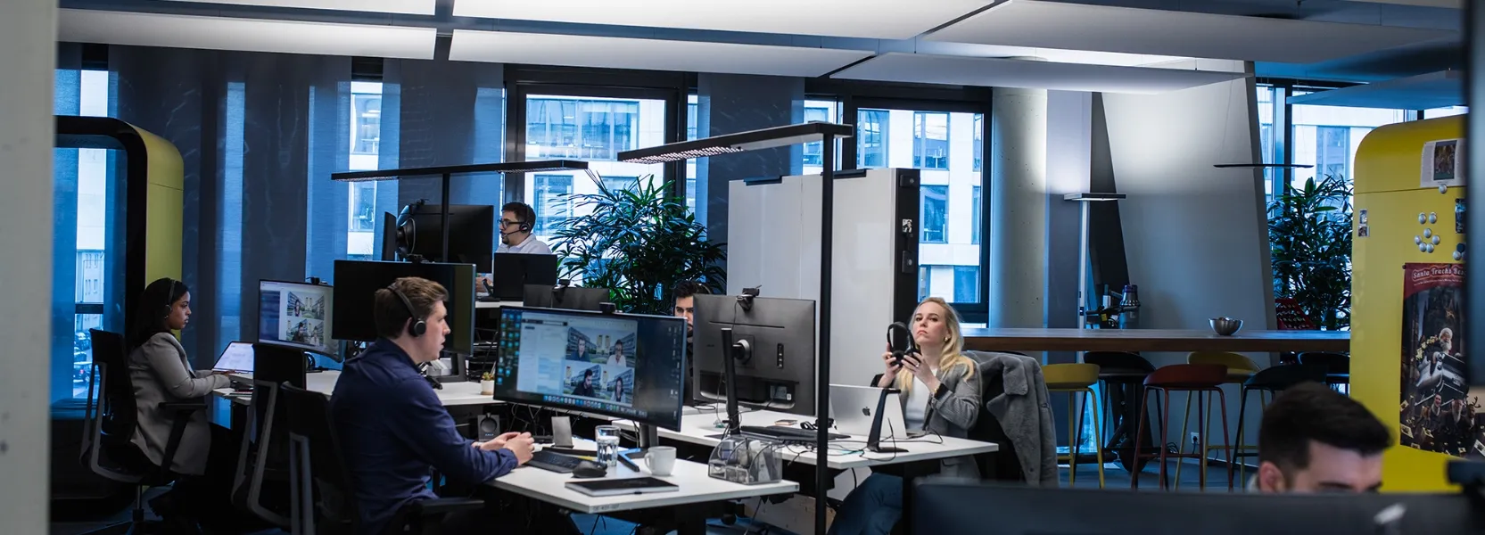 Vier Personen arbeiten in einem modernen, industriellen Labor mit Maschinen und Ausrüstung.