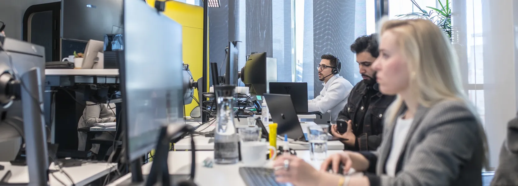 Vier Personen arbeiten in einem modernen, industriellen Labor mit Maschinen und Ausrüstung.