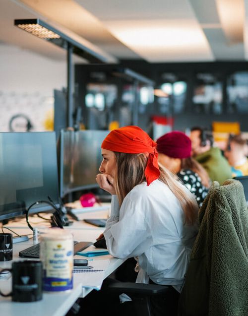 Mehrere Mitarbeiter sitzen mit Karnevalskostümen im Büro.