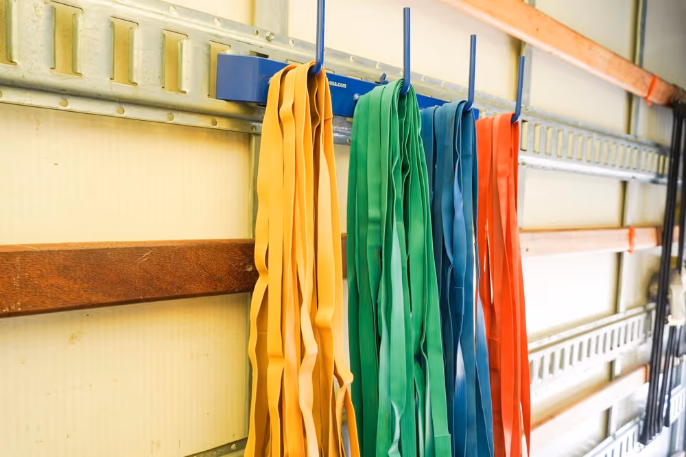 Organized moving truck interior showing colorful utility straps hanging on an e-track system, essential tools for secure moving in Austin, TX.