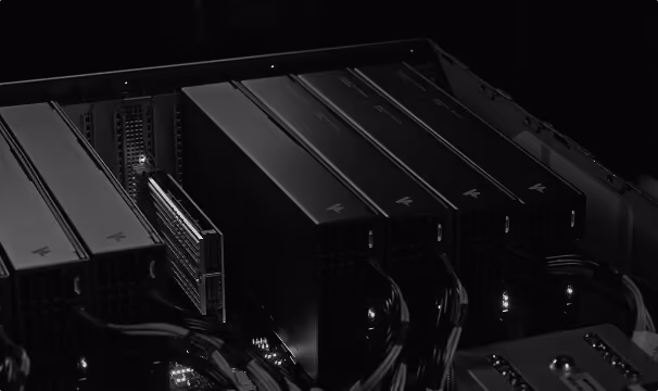 Close-up of several black PCIe expansion cards installed inside a computer case, showing power cables connected to the components.