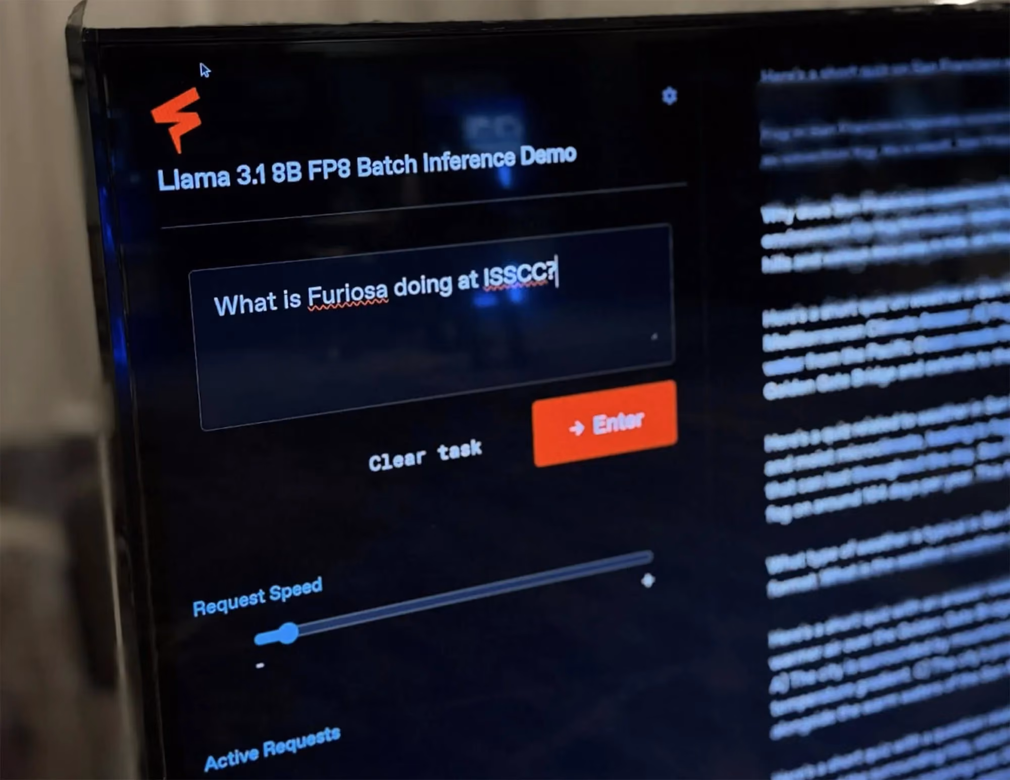 Close-up of a monitor displaying a Furiosa demo interface titled “Llama 3.1 8B FP8 Batch Inference Demo,” showing a text prompt asking “What is Furiosa doing at ISSCC?” with inference controls visible.
