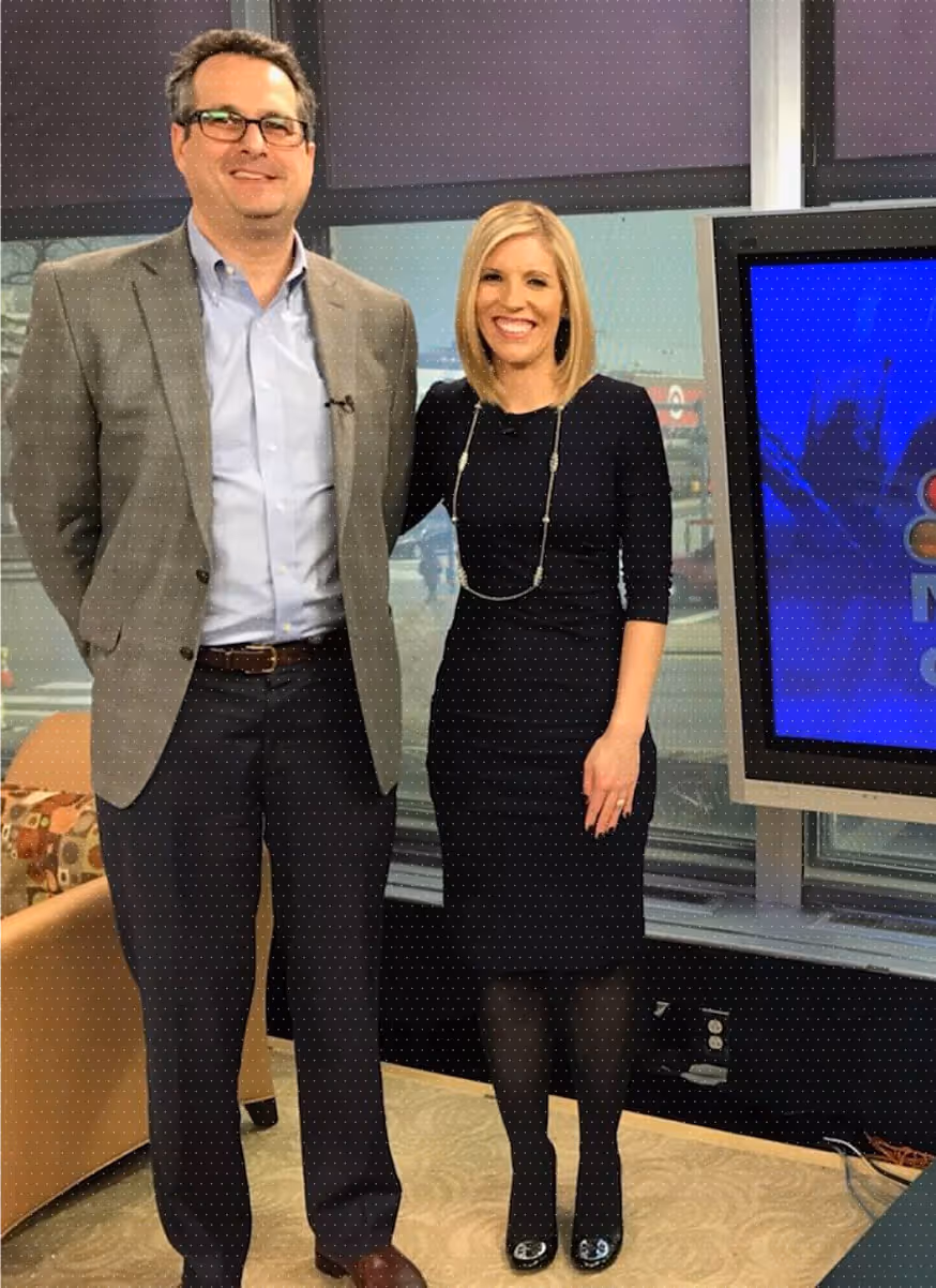 James H. Lee next to a woman inside a studio with a television screen.