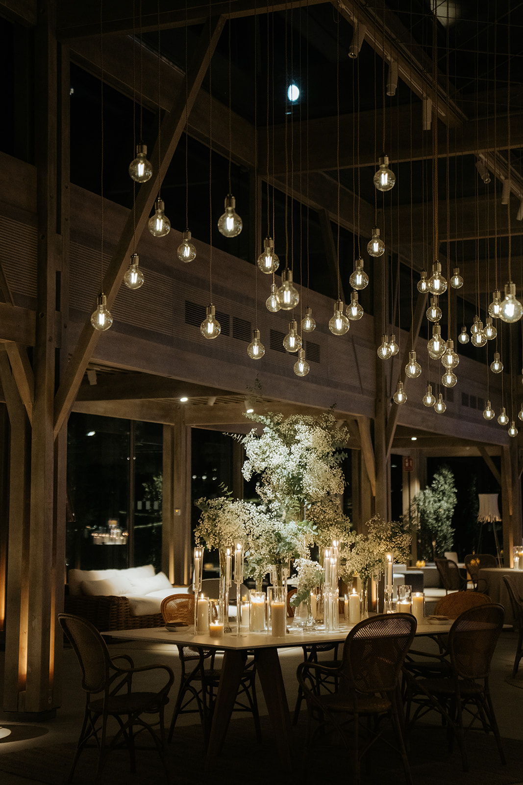 Black and white photo of a couple embracing during a dance in a dimly lit venue with a bright light above.