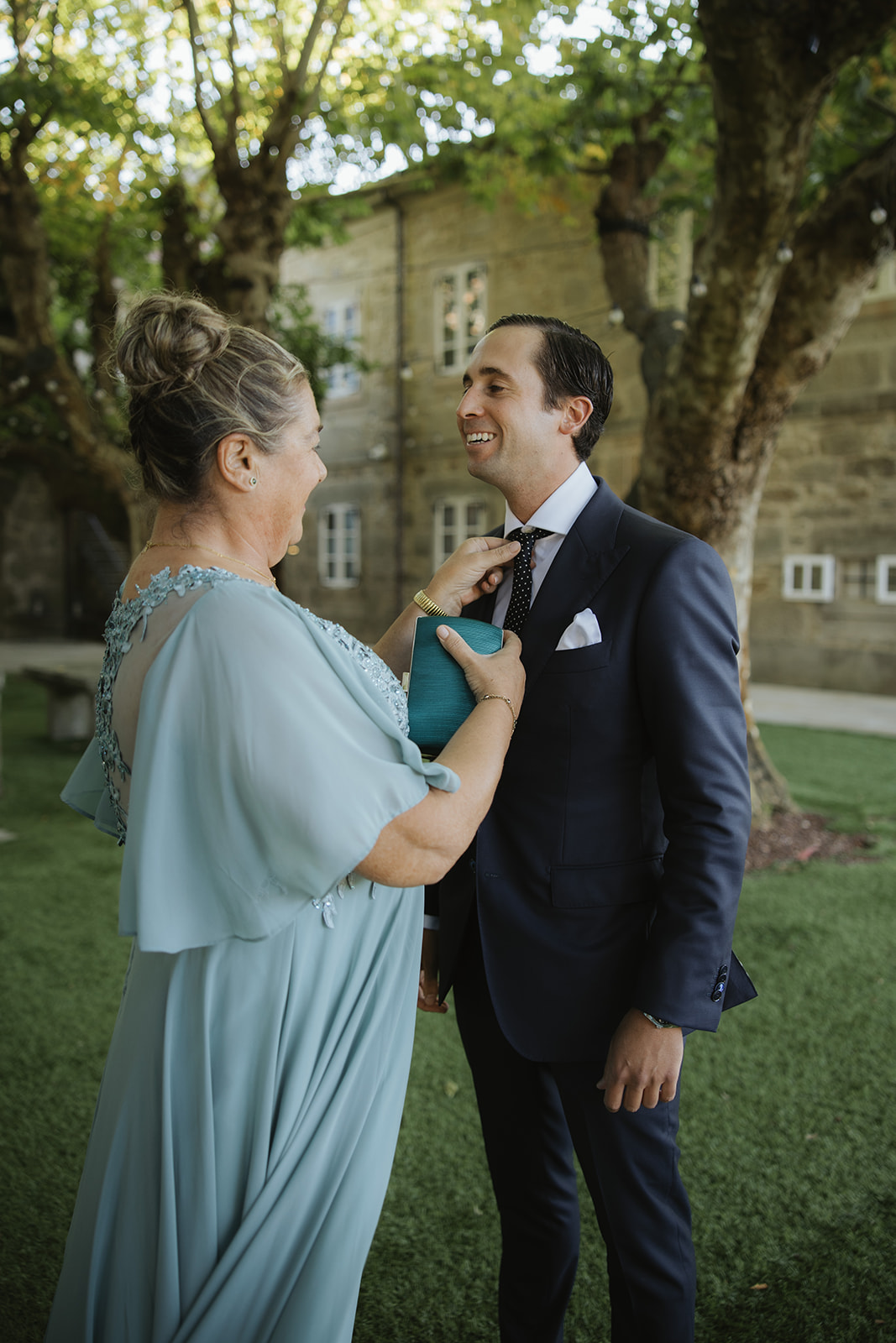 Bride and groom standing before a priest in a grand church with ornate golden altar and stained glass windows during a wedding ceremony.