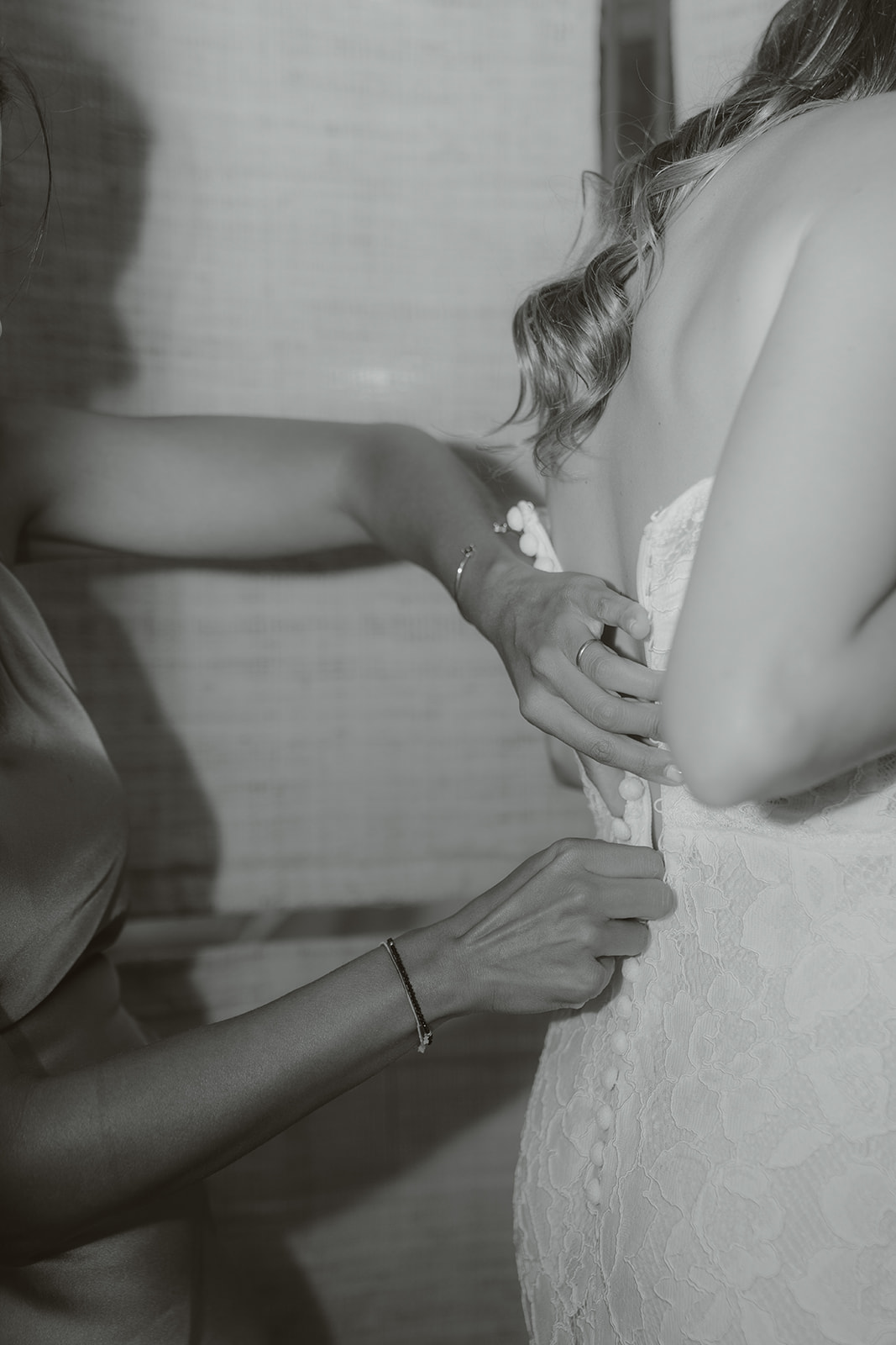 Person holding a gold engagement ring above a black ring box, wearing a white shirt and black pants.