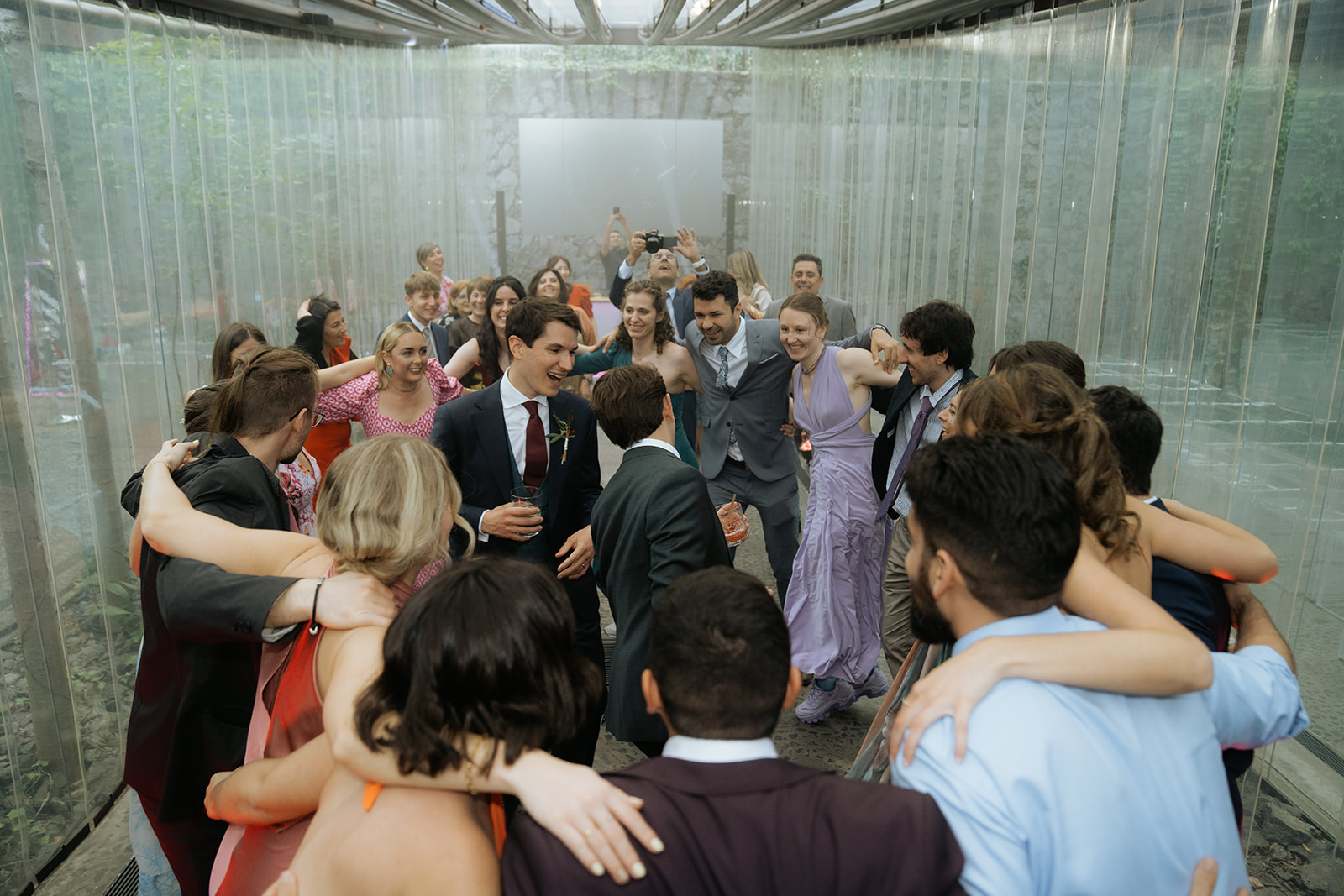 Black and white photo of a man adjusting his formal shirt and bow tie while looking at his reflection in an oval mirror.