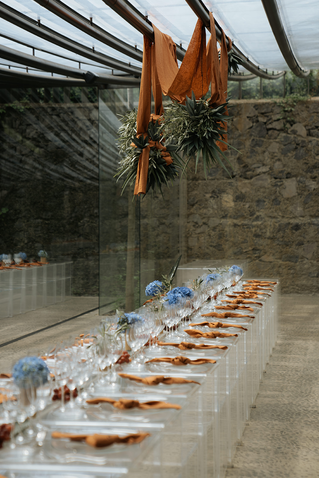 Bride and groom holding hands during wedding ceremony, bride wearing lace dress and groom in dark suit.