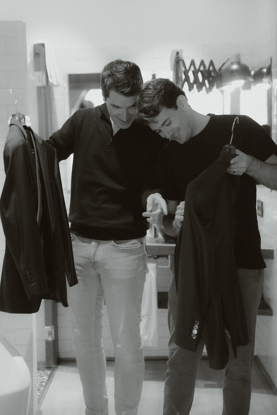 Person holding a gold engagement ring above a black ring box, wearing a white shirt and black pants.