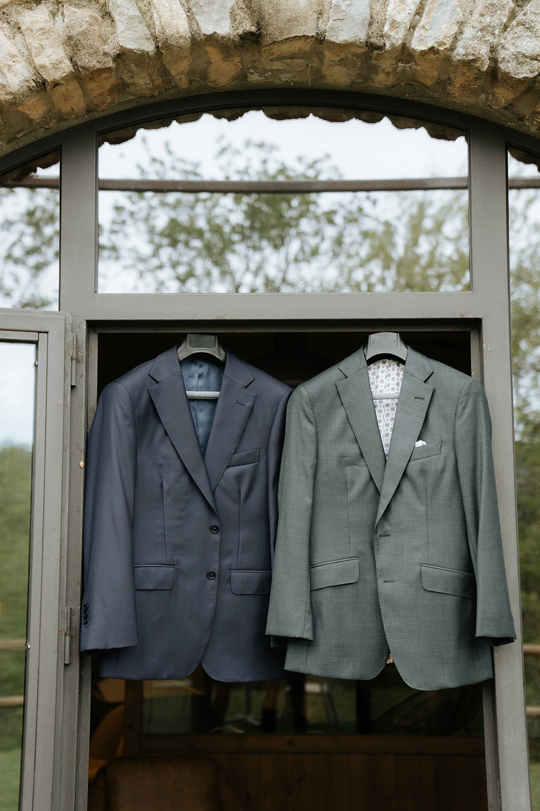 Two men in suits sharing an emotional embrace indoors.