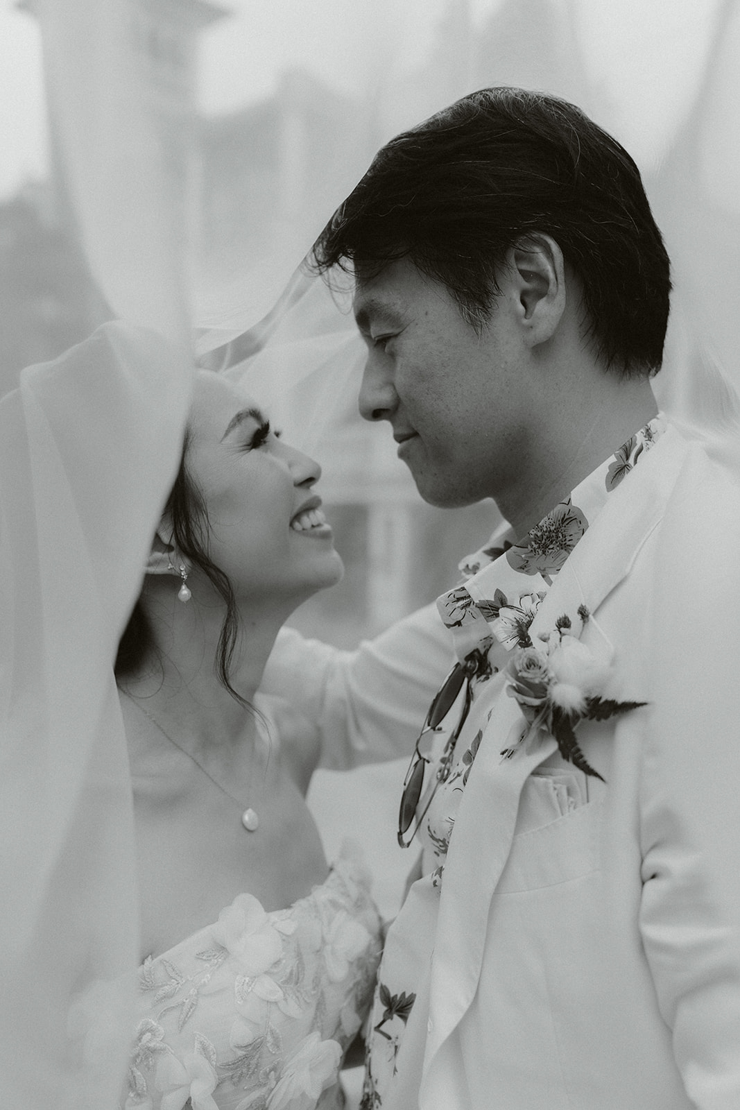 Close-up of a person fastening a gold cufflink on another person’s white dress shirt cuff.