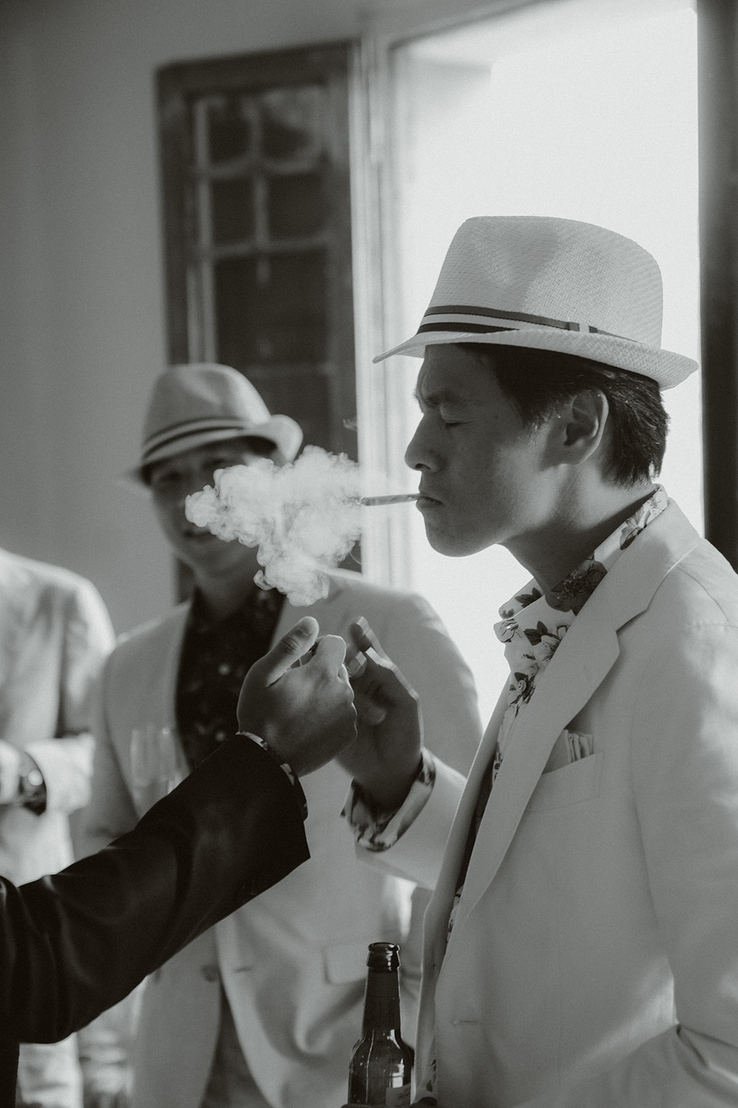 Pair of black patent leather and suede oxford dress shoes on a light marble floor.