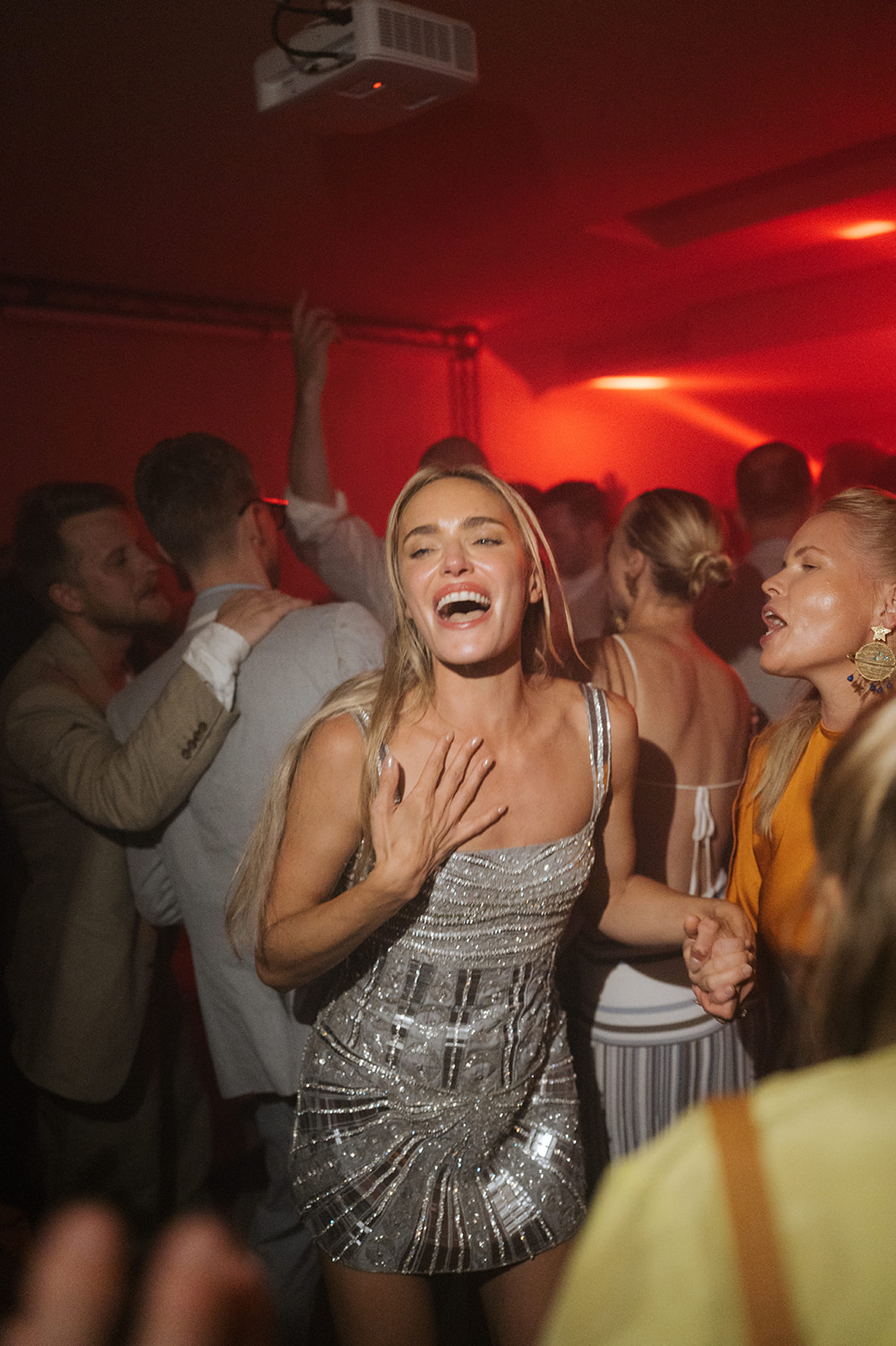 Close-up of a person fastening a gold cufflink on another person’s white dress shirt cuff.
