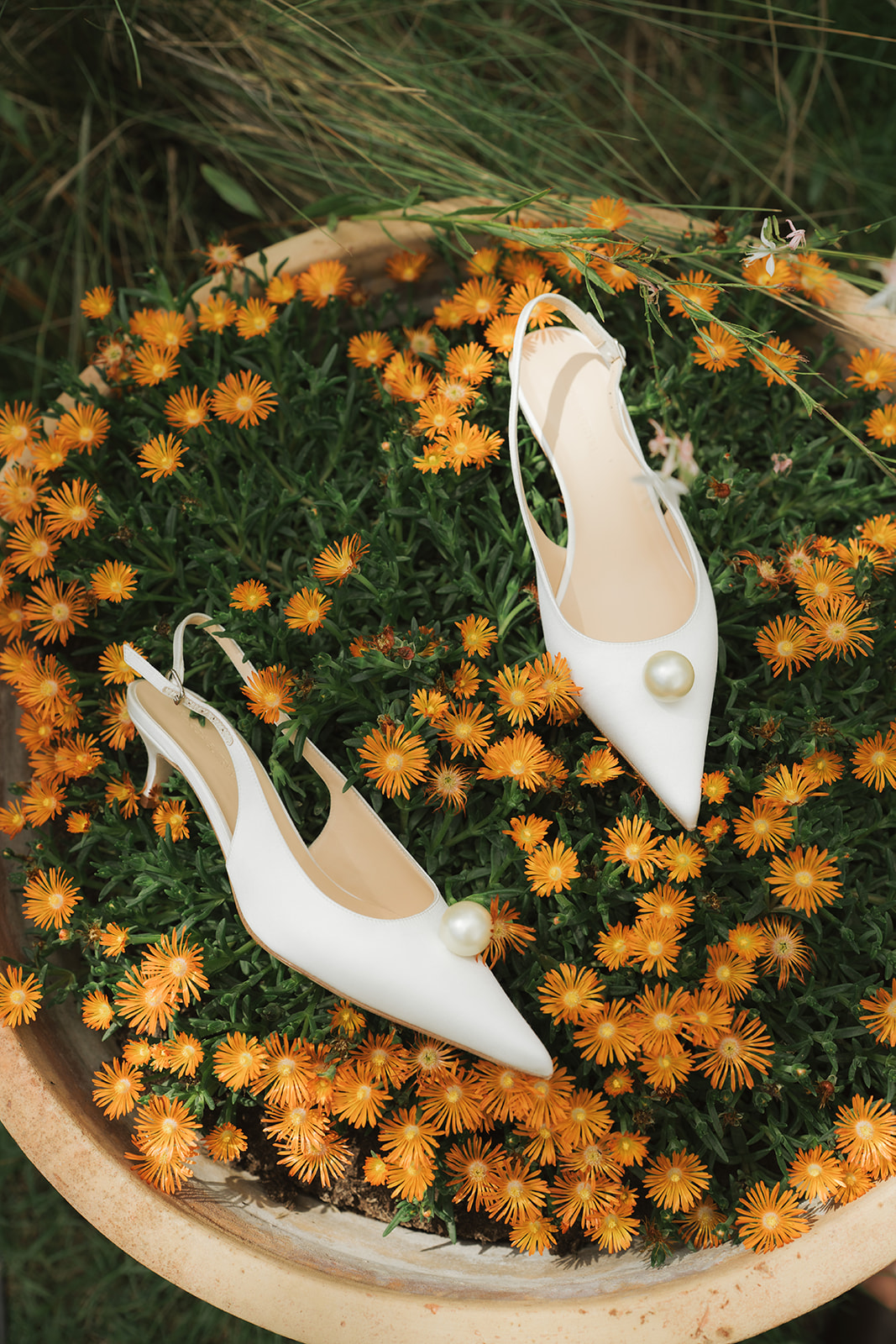 Person holding a gold engagement ring above a black ring box, wearing a white shirt and black pants.