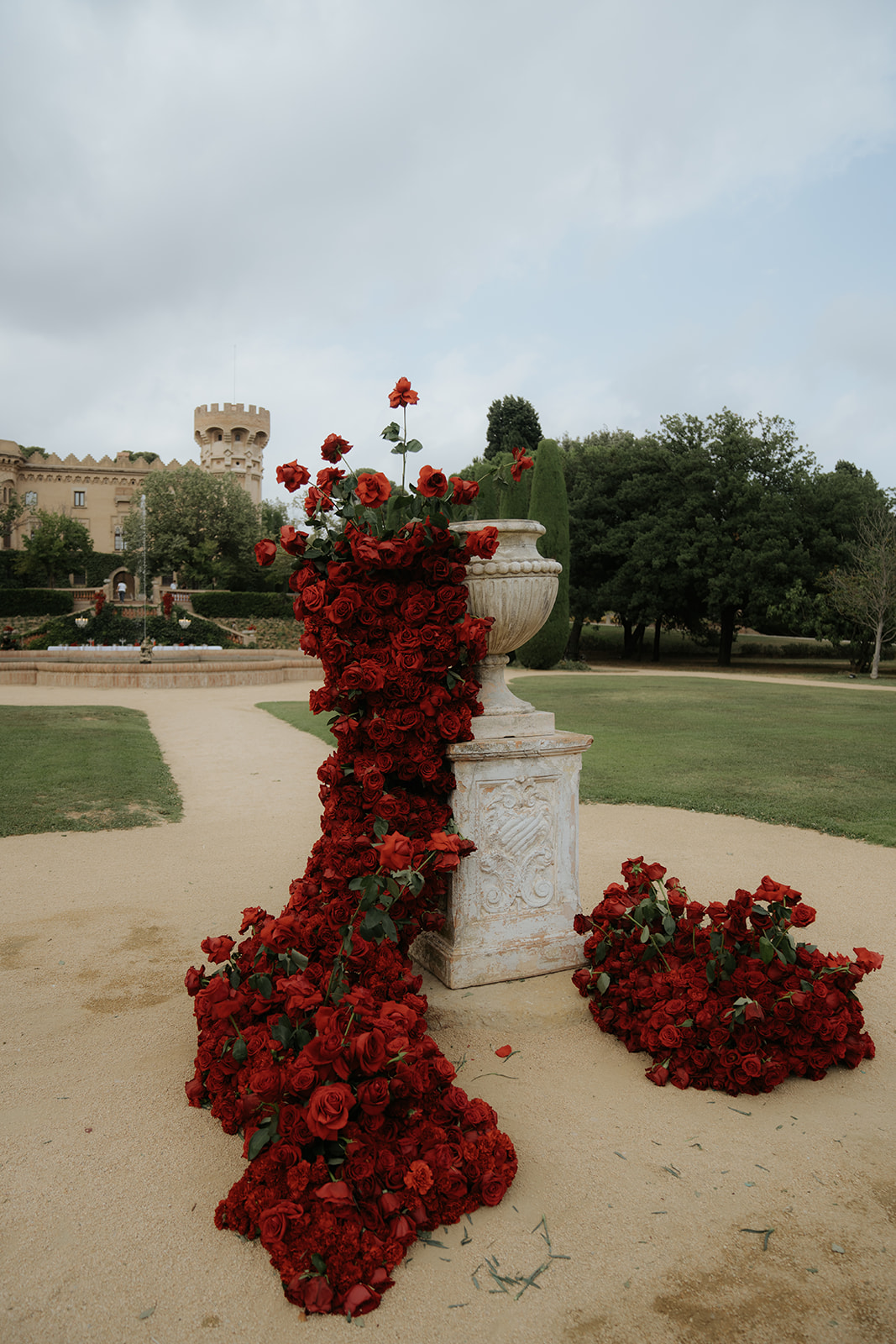 Woman in silky white robe sitting on a brown couch holding a bouquet of white roses.