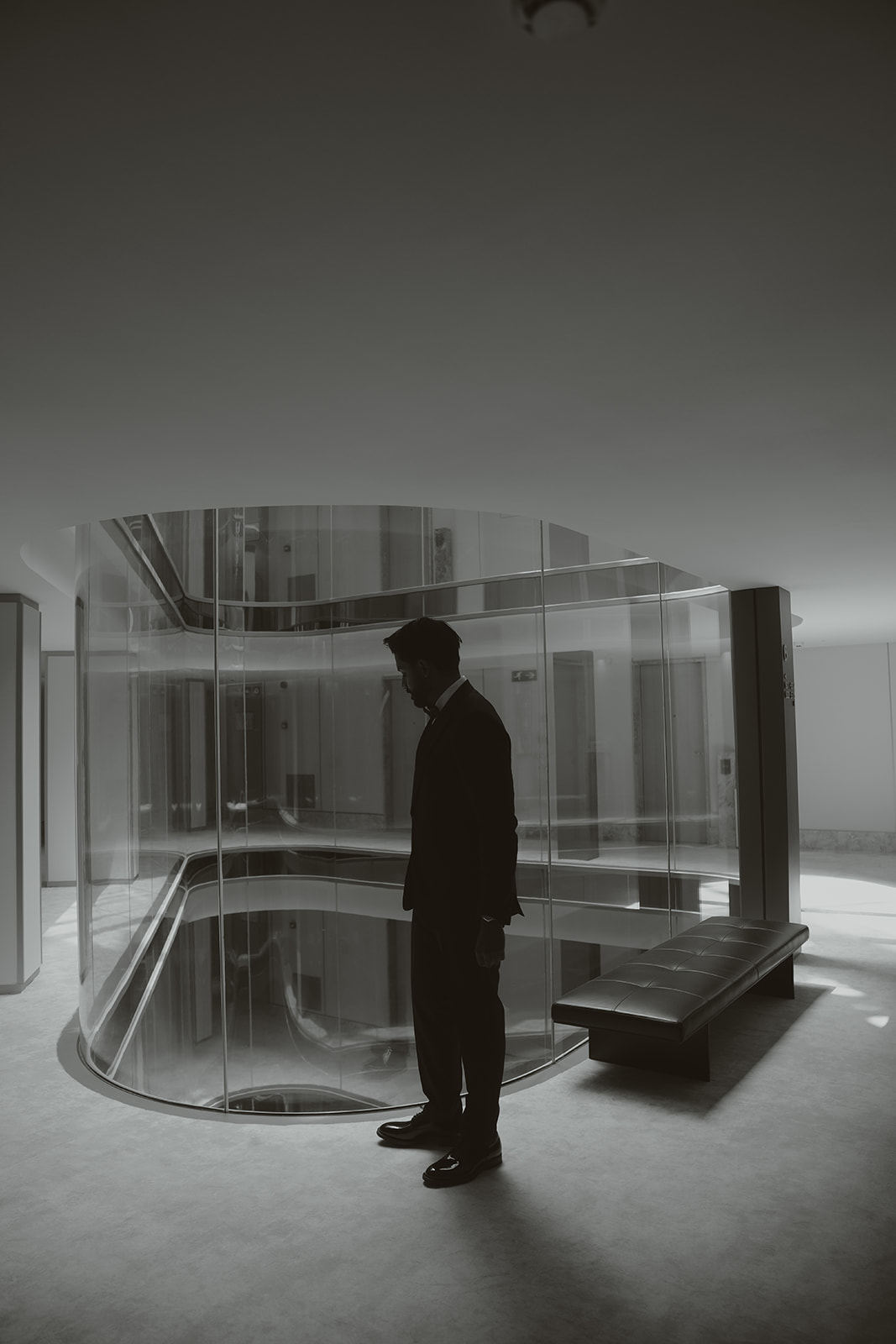 Two men in suits sharing an emotional embrace indoors.