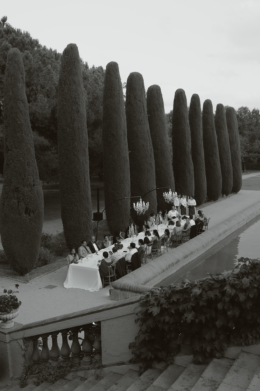 Close-up of a person fastening a gold cufflink on another person’s white dress shirt cuff.