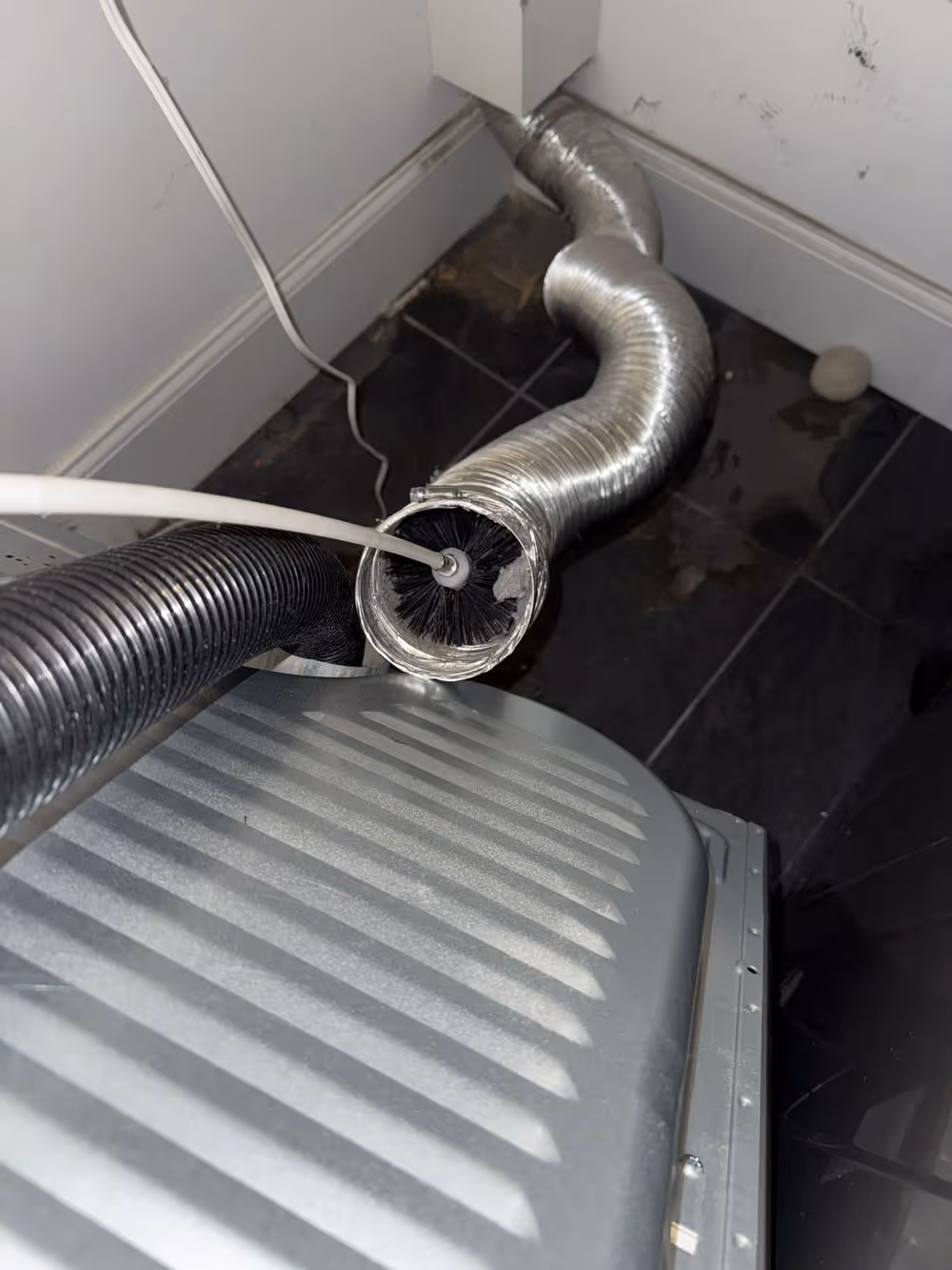 Pollard's Dryer Vent Cleaning is using a special tool to clean out a dryer vent.