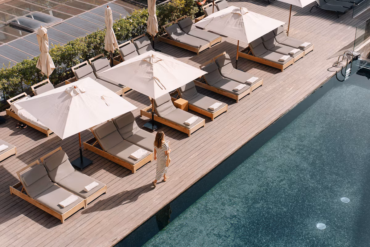 Artisanal leather tannery with workers standing and handling hides in large stone dyeing vats filled with colorful liquids.