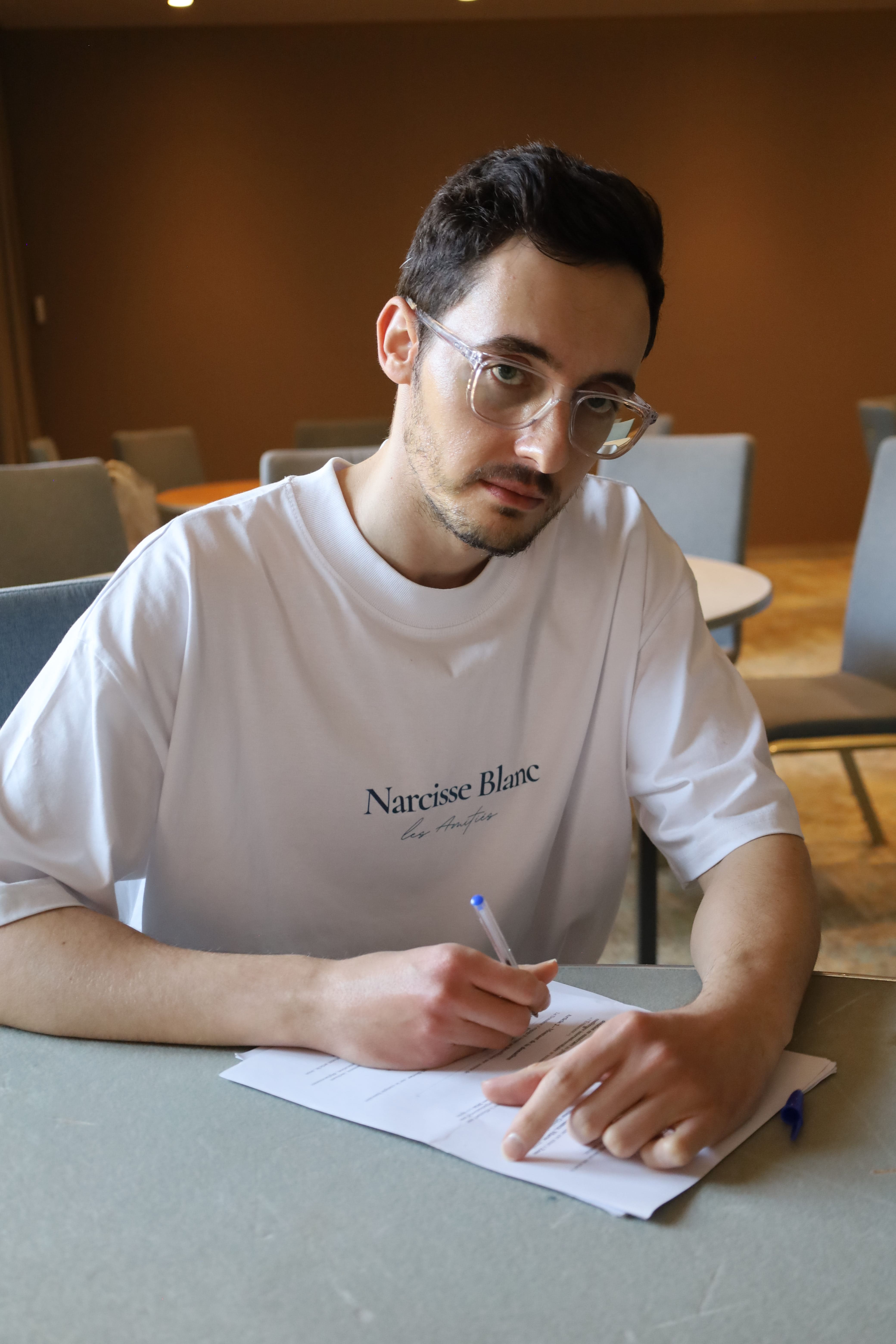 Three round huts with thatched roofs on a dry, rocky desert landscape with winding stone paths.