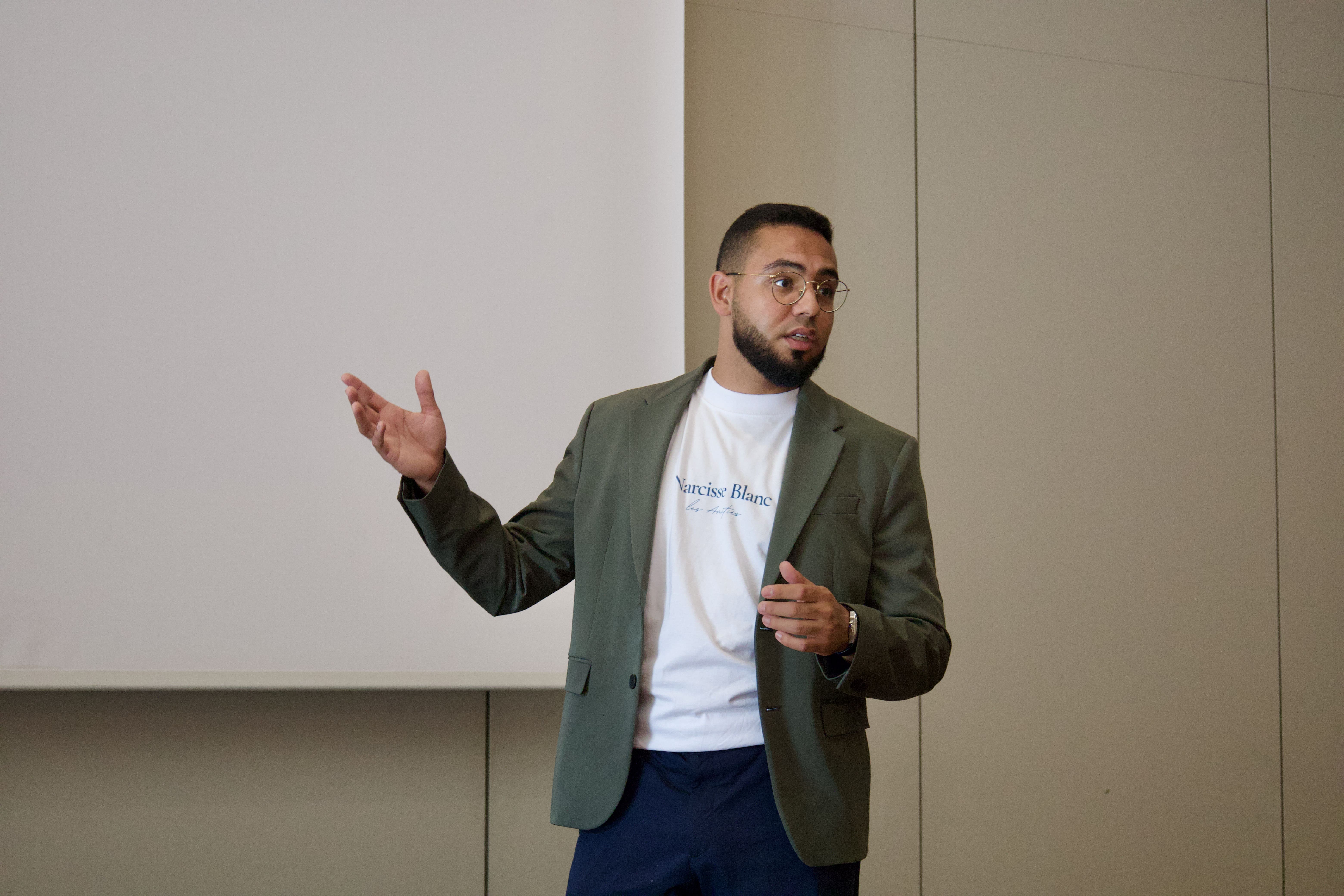 Conference room with rows of patterned chairs facing a projector screen displaying Le Casablanca Hotel logo.