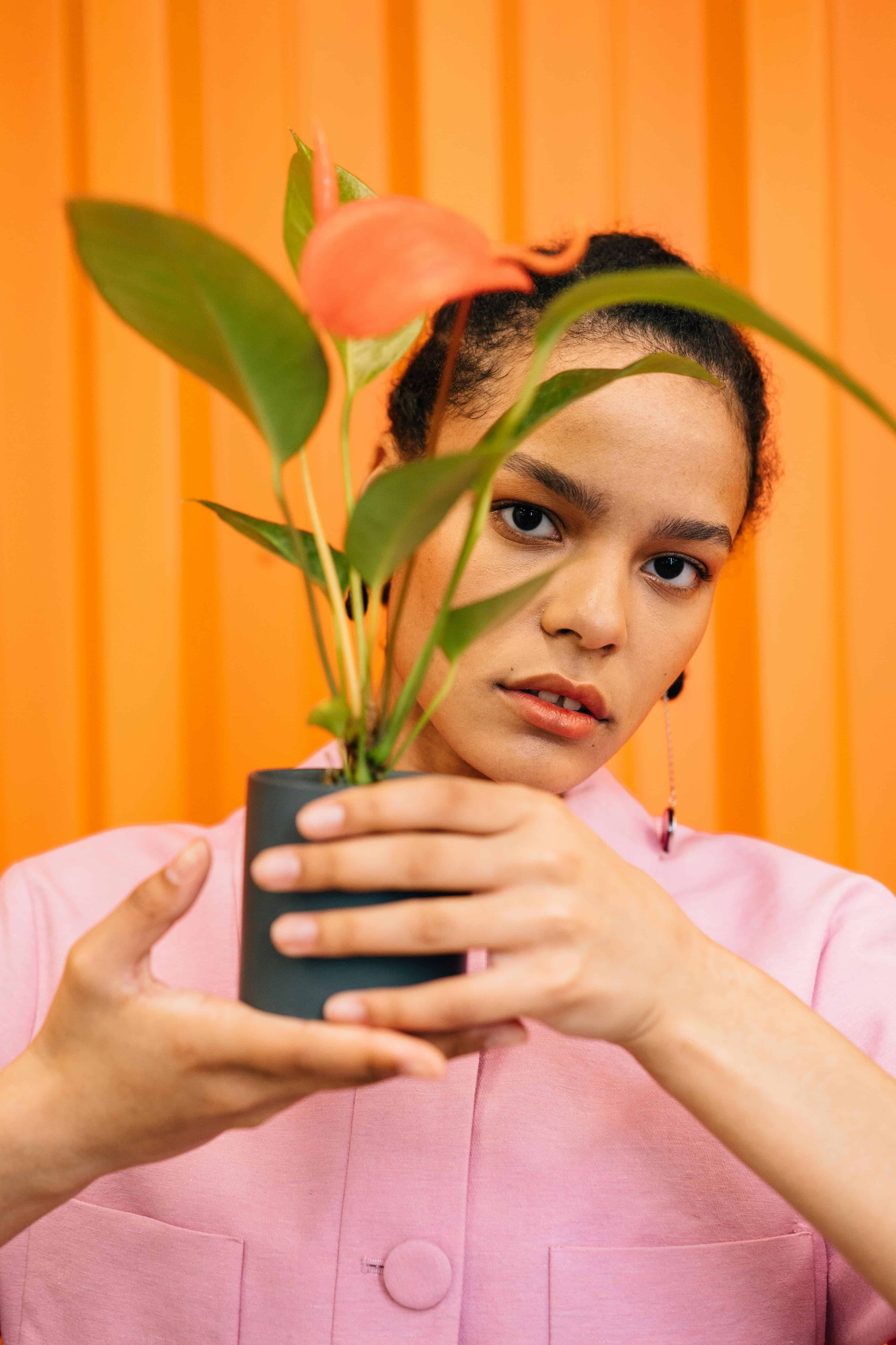 woman holding a plant that has a flower