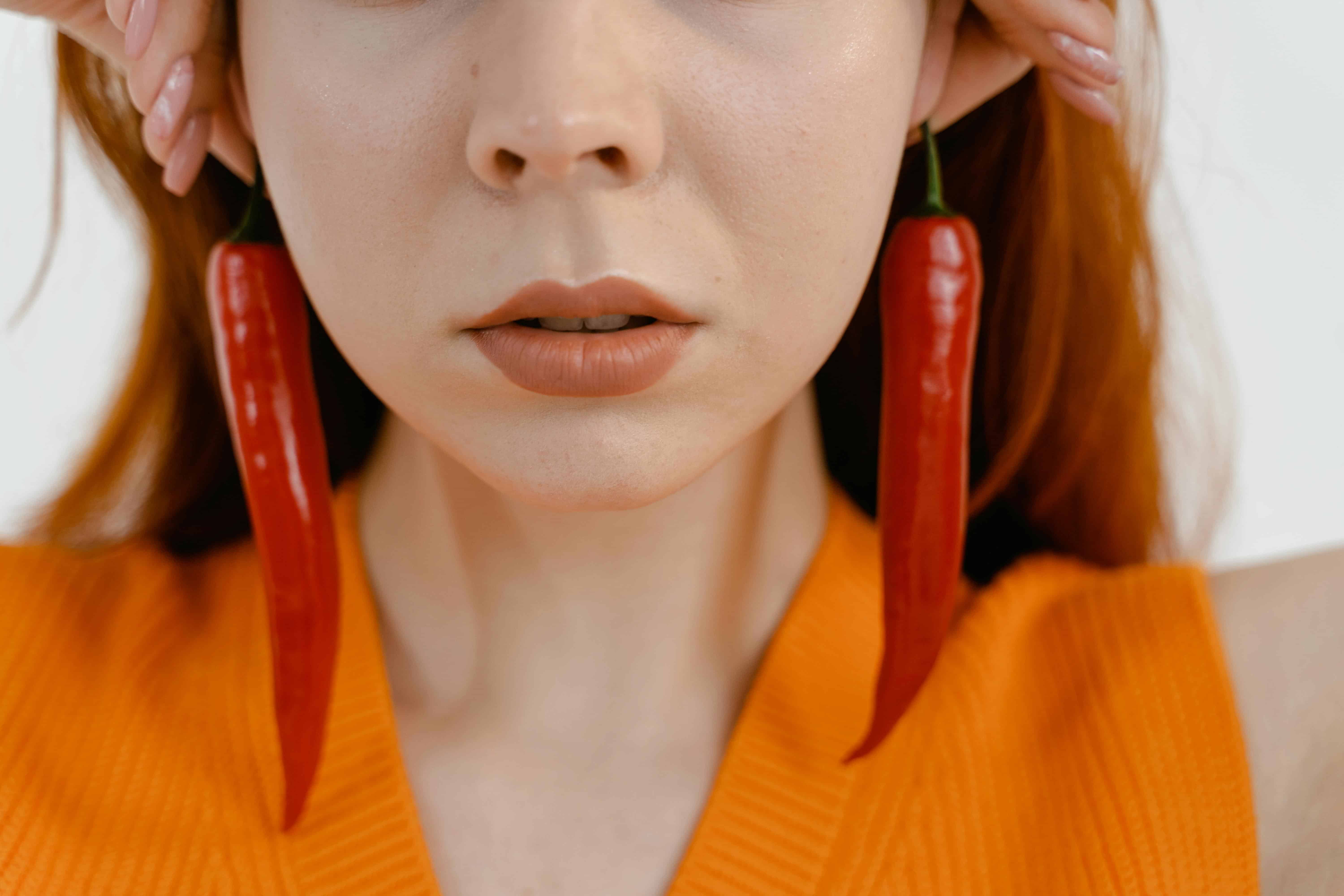 woman wearing earrings that look like long chili peppers