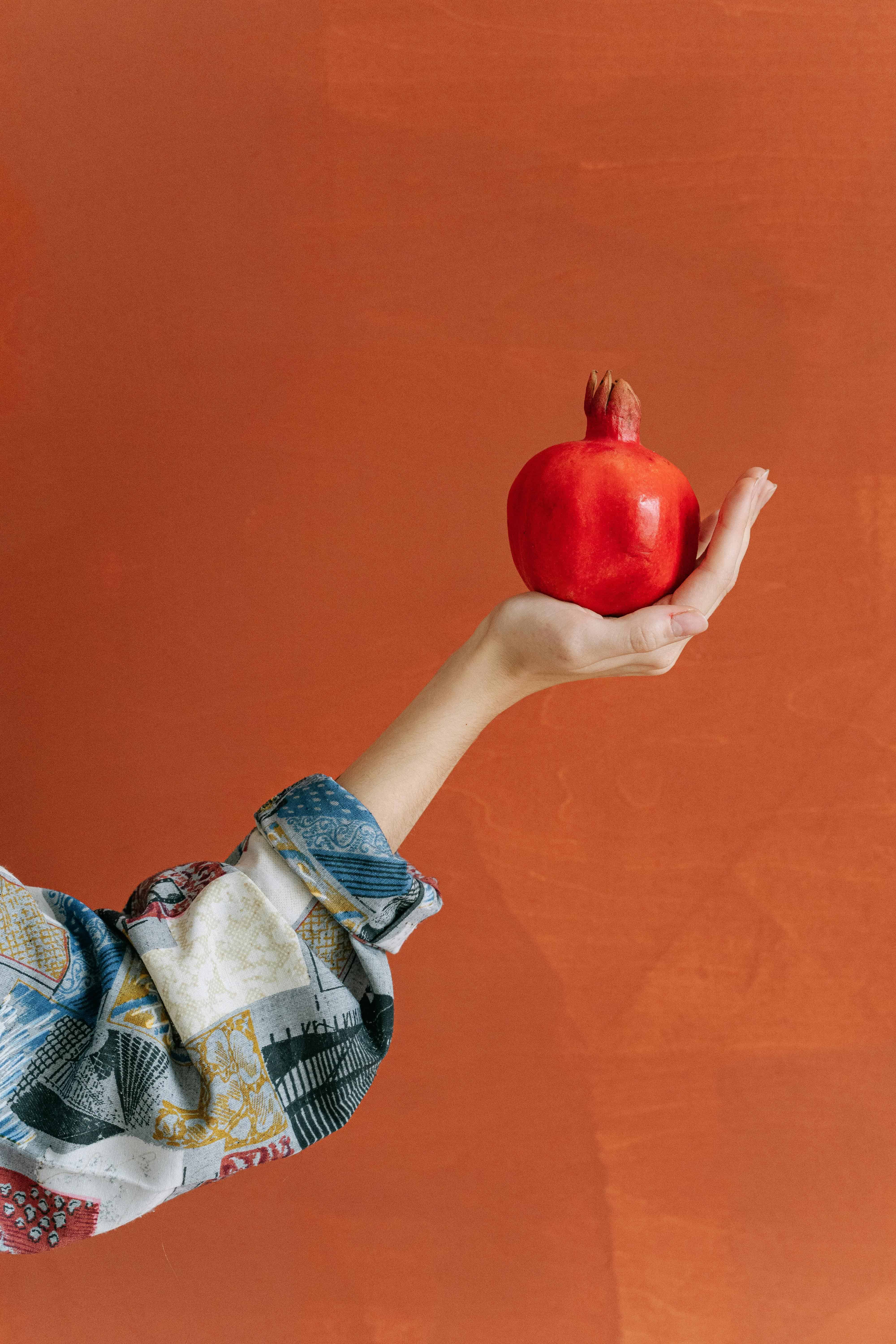 a feminine hand holding a fruit