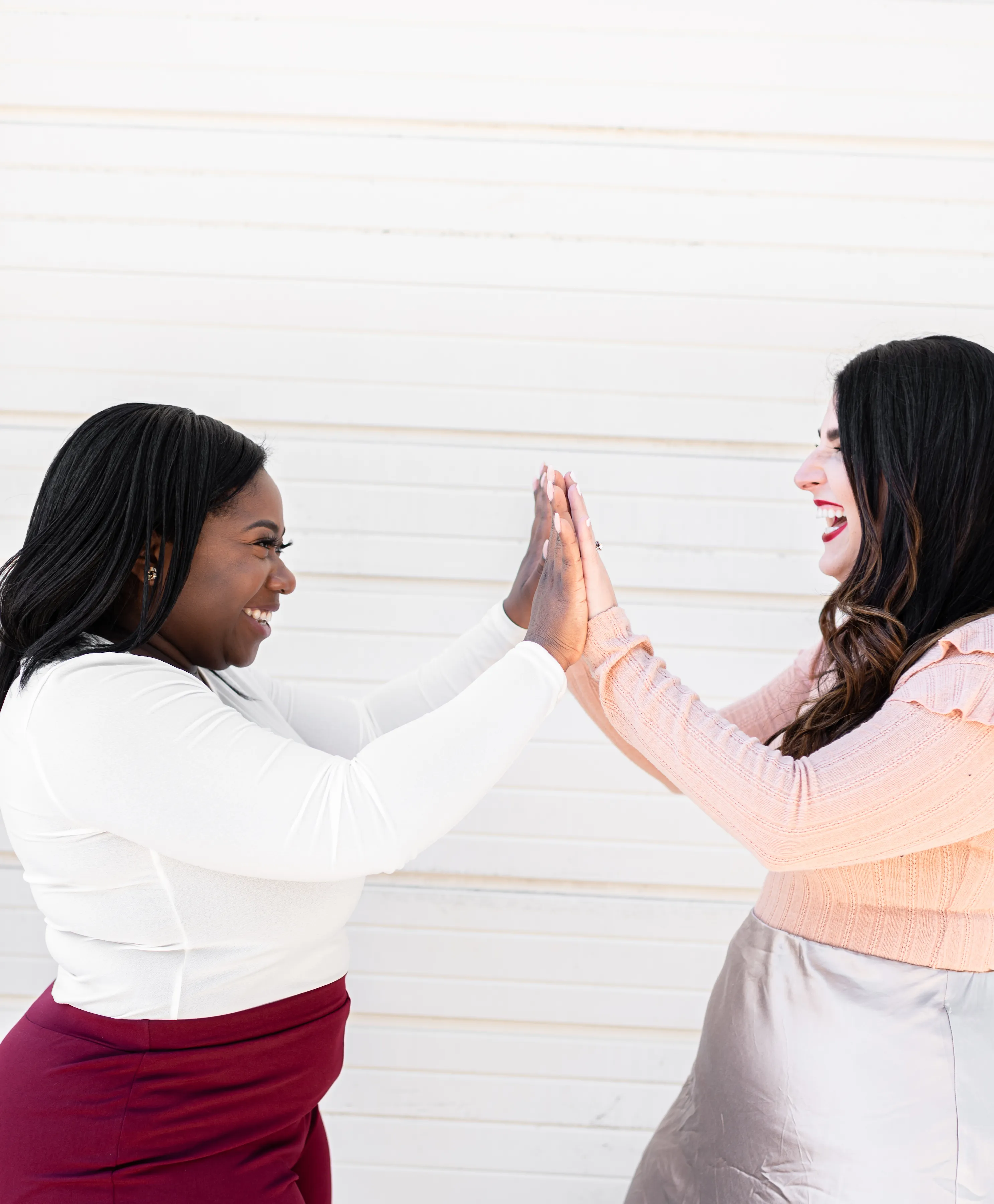 a black and white woman giving each other a high 5